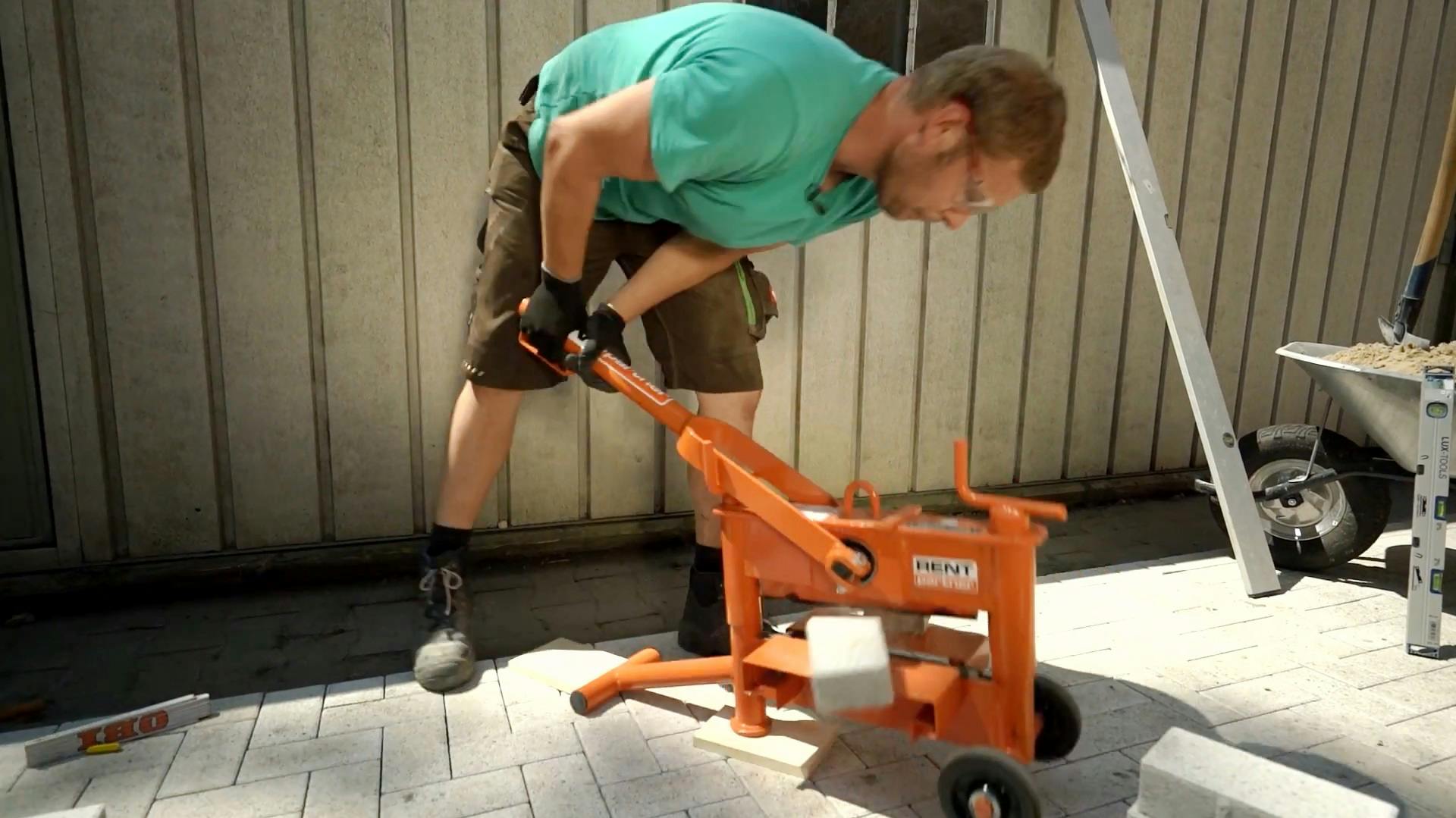 Heimwerker trennt Terrassenplatten mit einem Steintrenner.