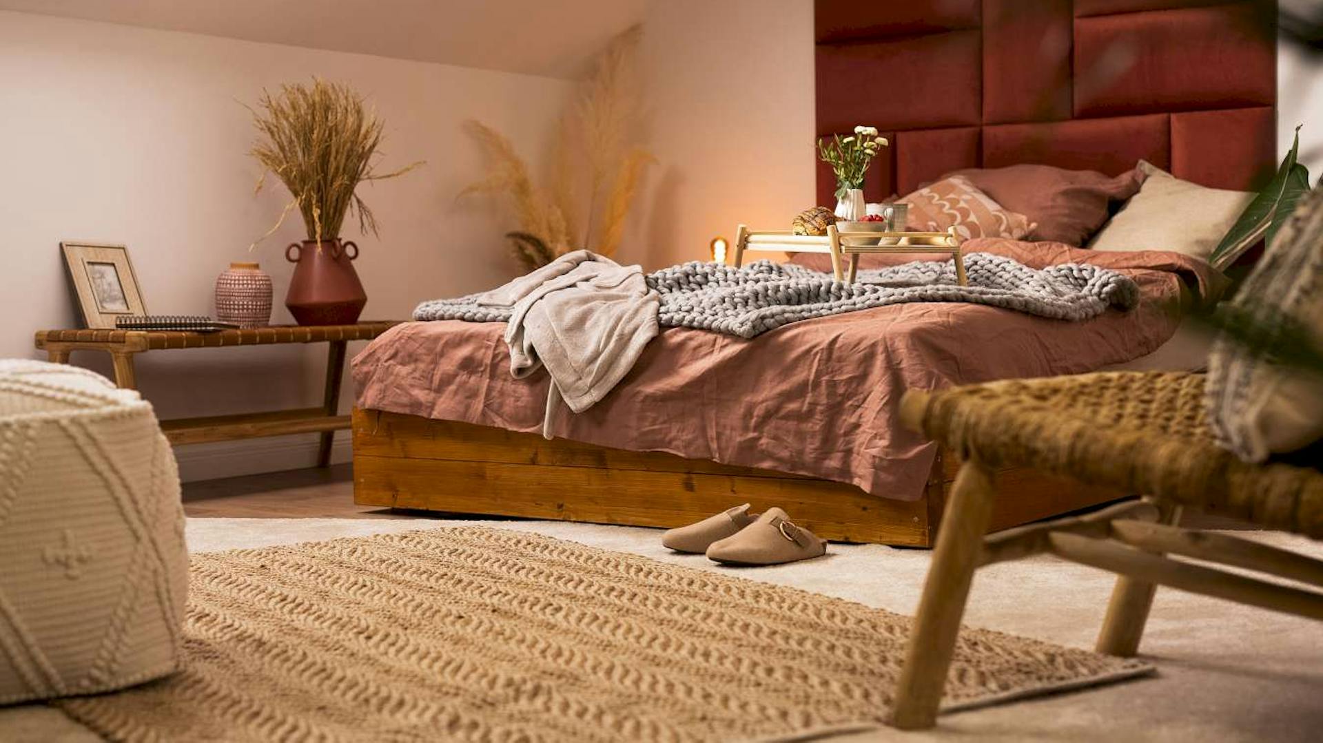 Gemütliches Schlafzimmer mit warmen Farbtönen und vielen Textilien