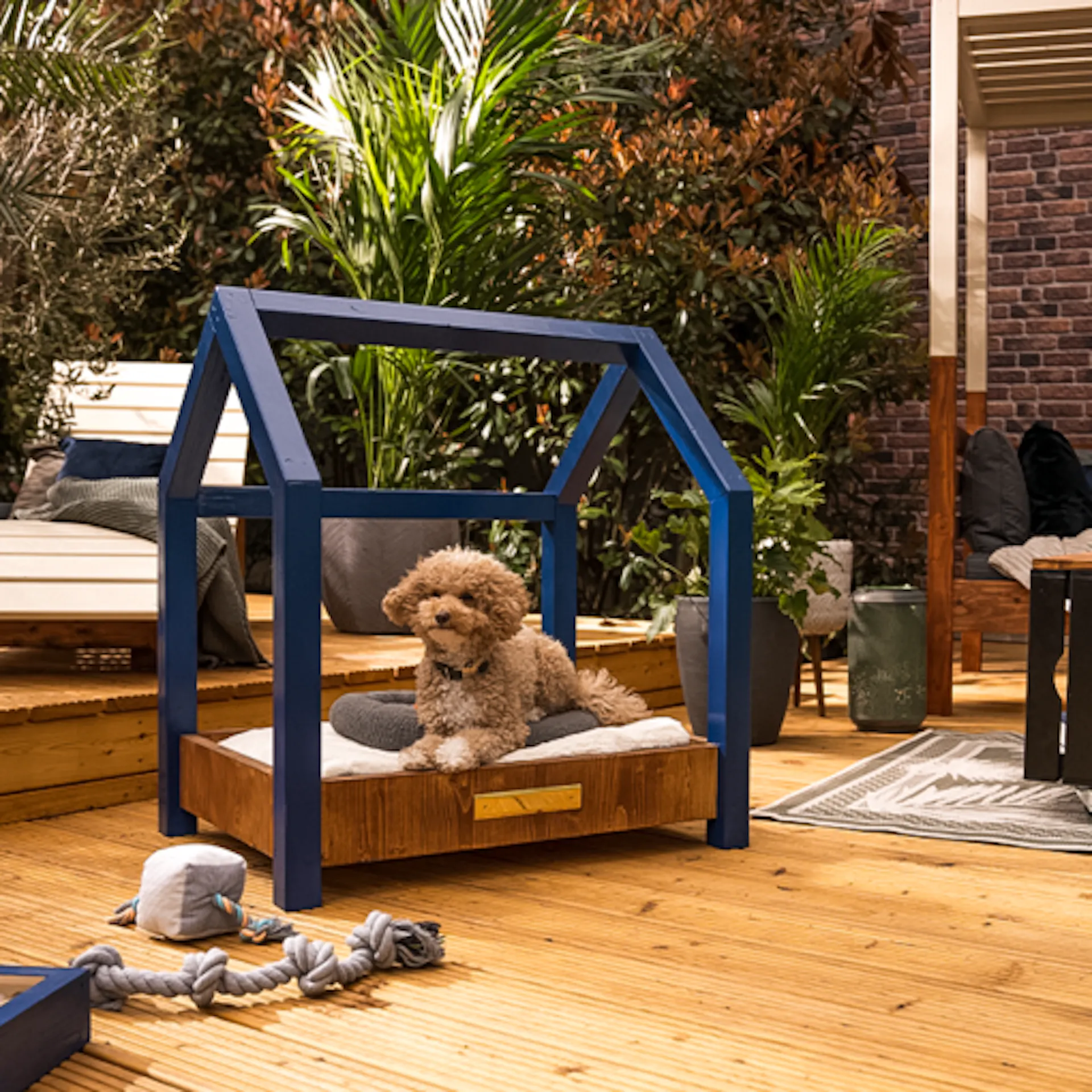 Hundebett Moritz steht auf einer großen Terrasse, wo Wellenliege Lena und Sonneninsel Helena im Hintergrund sind.
