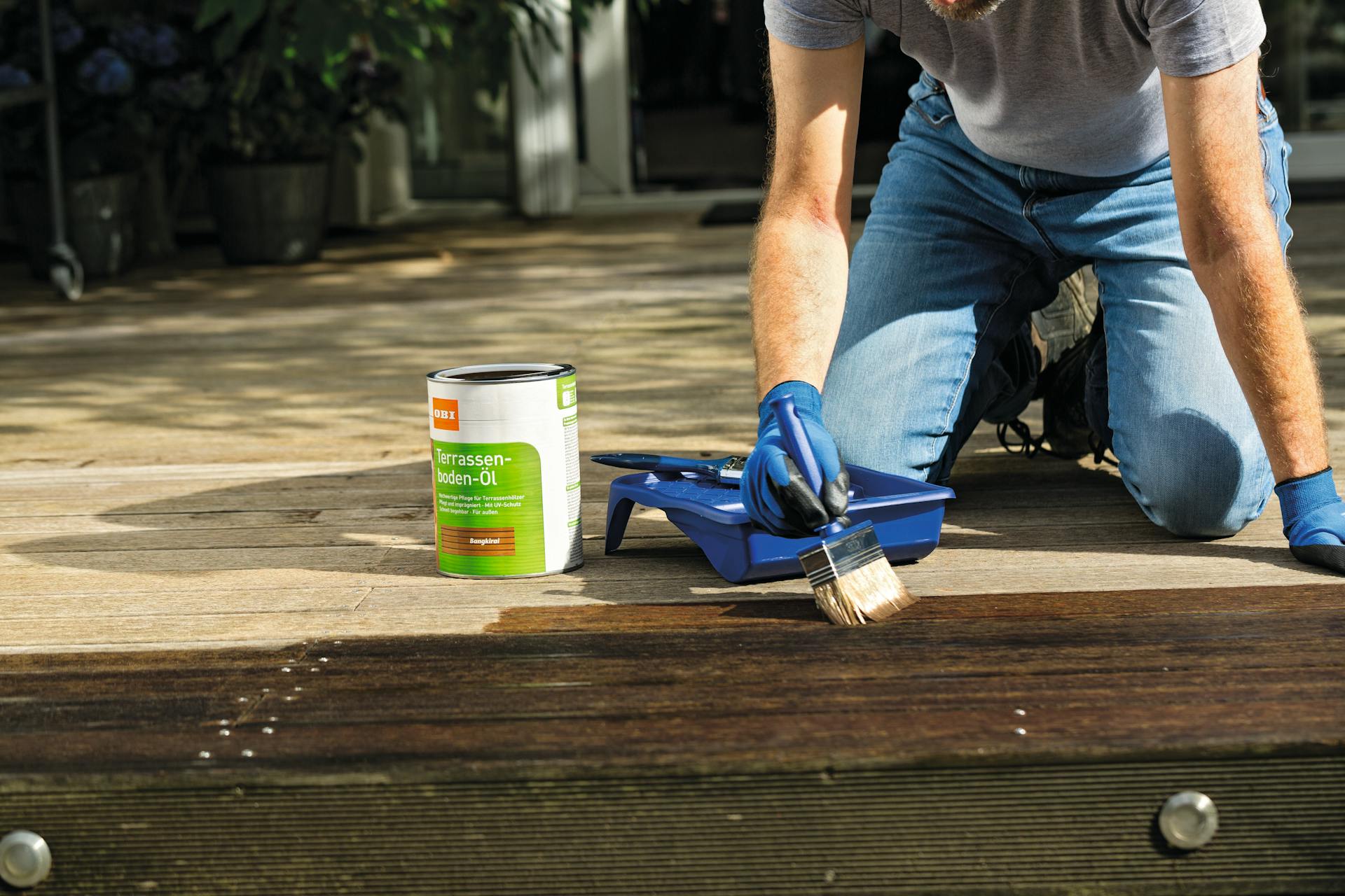 Ruka so štetcom na drevenom paneli