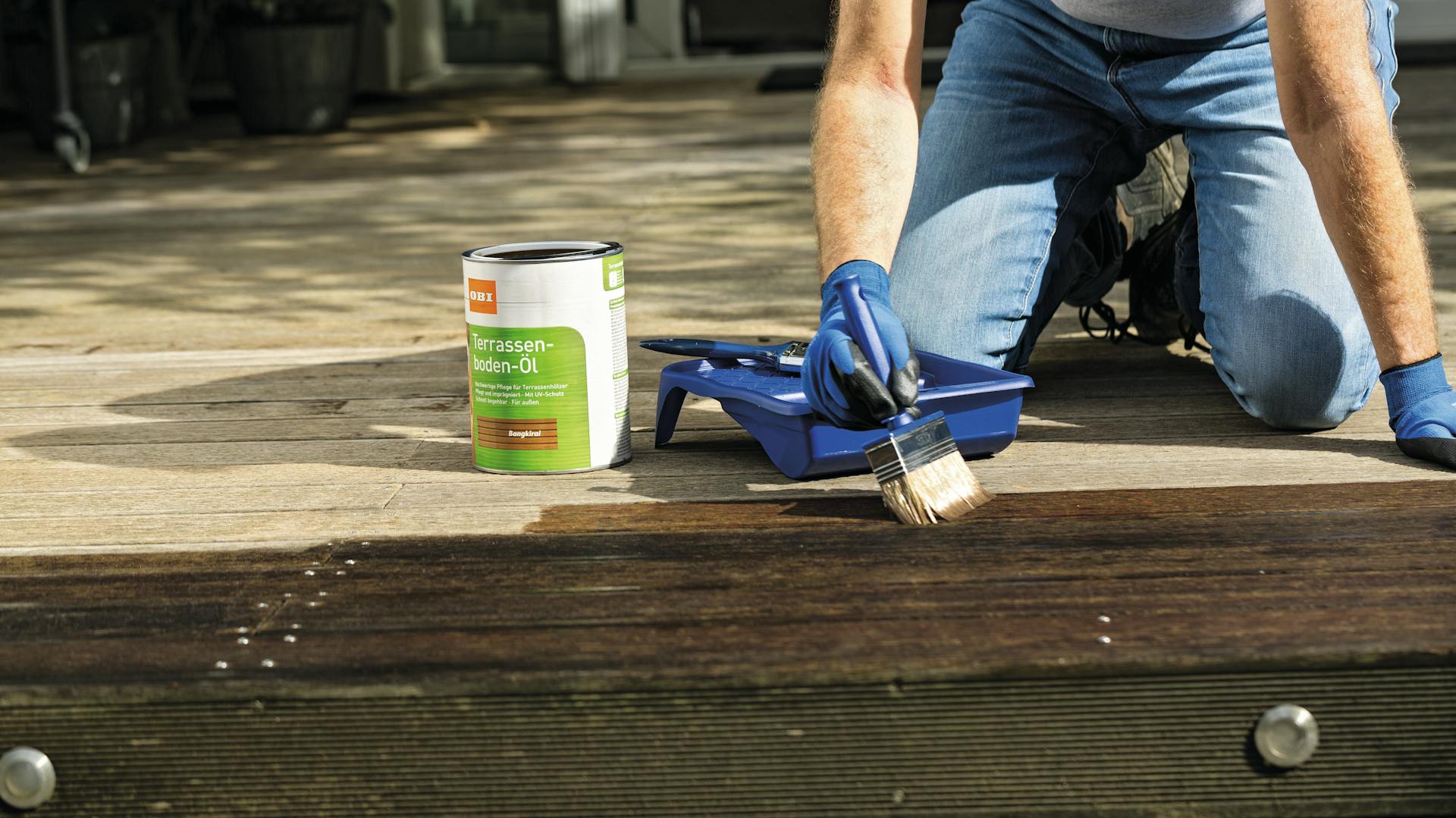 Hand mit Pinsel auf Holzplatte