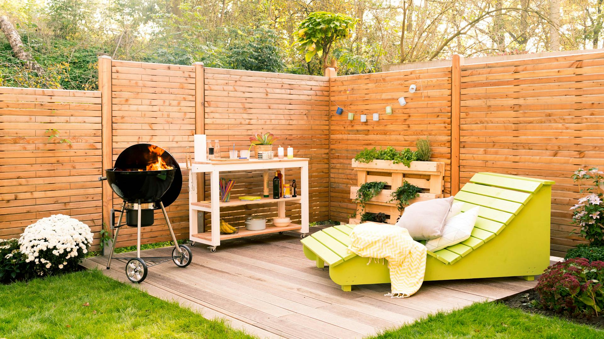 Grillplatz im Garten mit Sitzgelegenheit und Sichtschutz