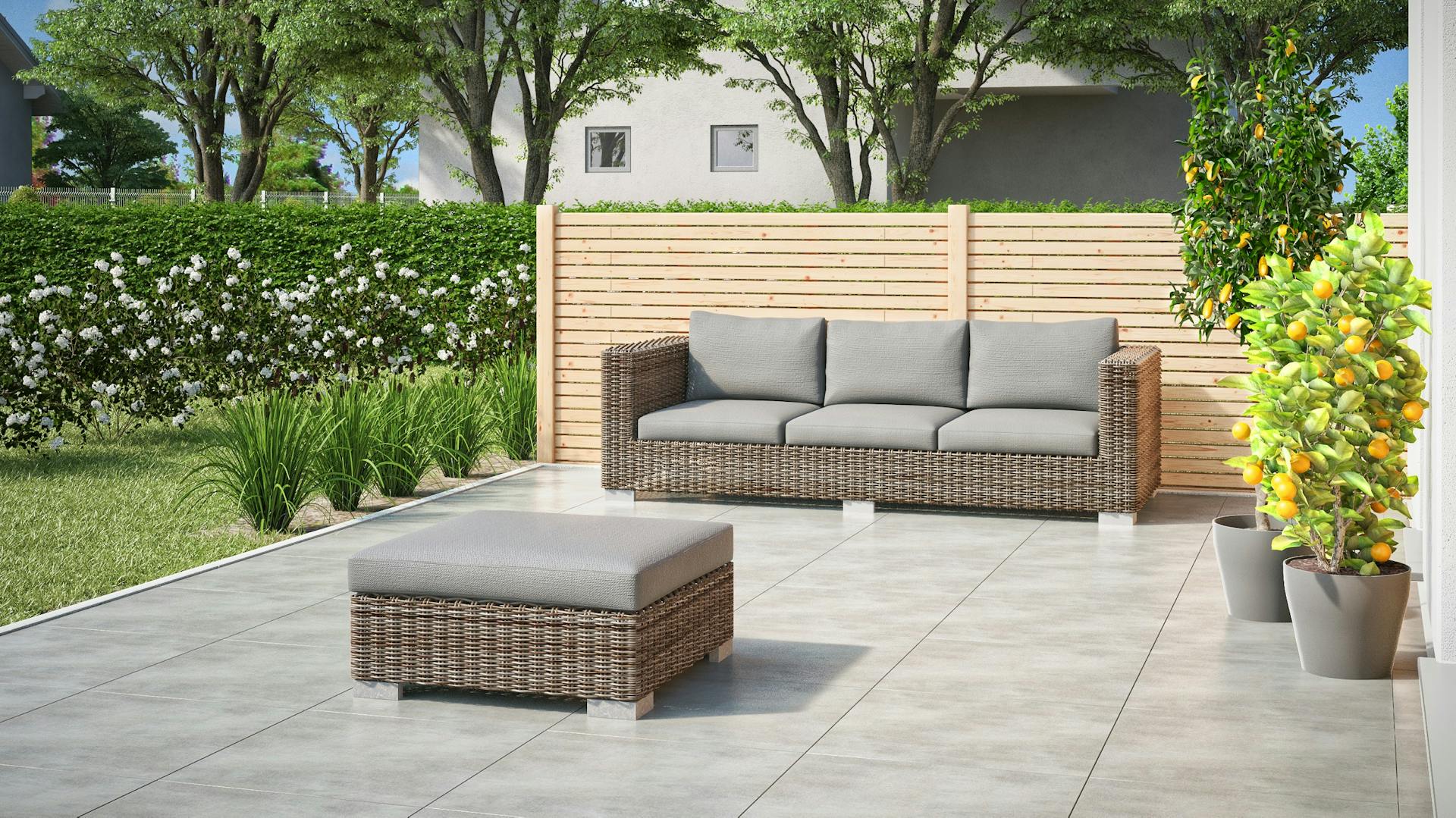 Terrazza con vista laterale, pavimento piastrellato, mobili lounge e piante di limoni in vaso.
