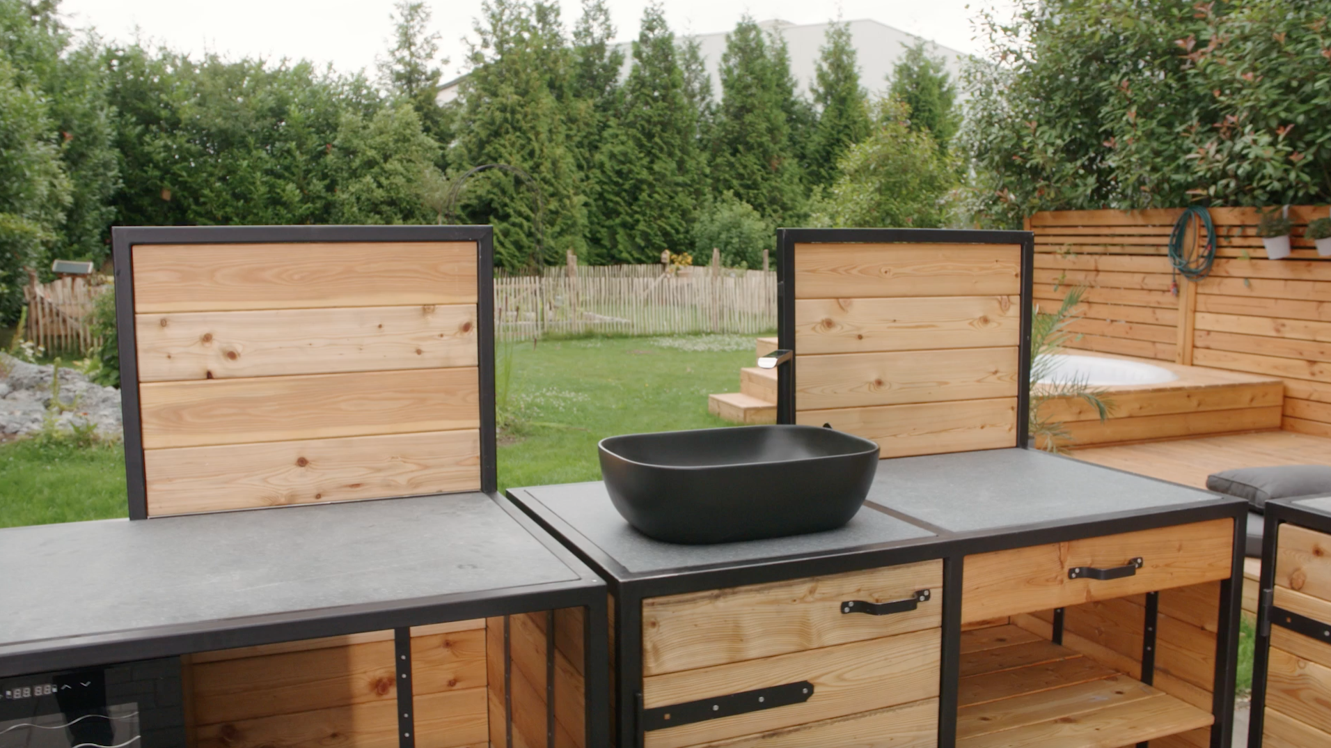 Cucina esterna finita con lavandino incorporato e pareti posteriori.