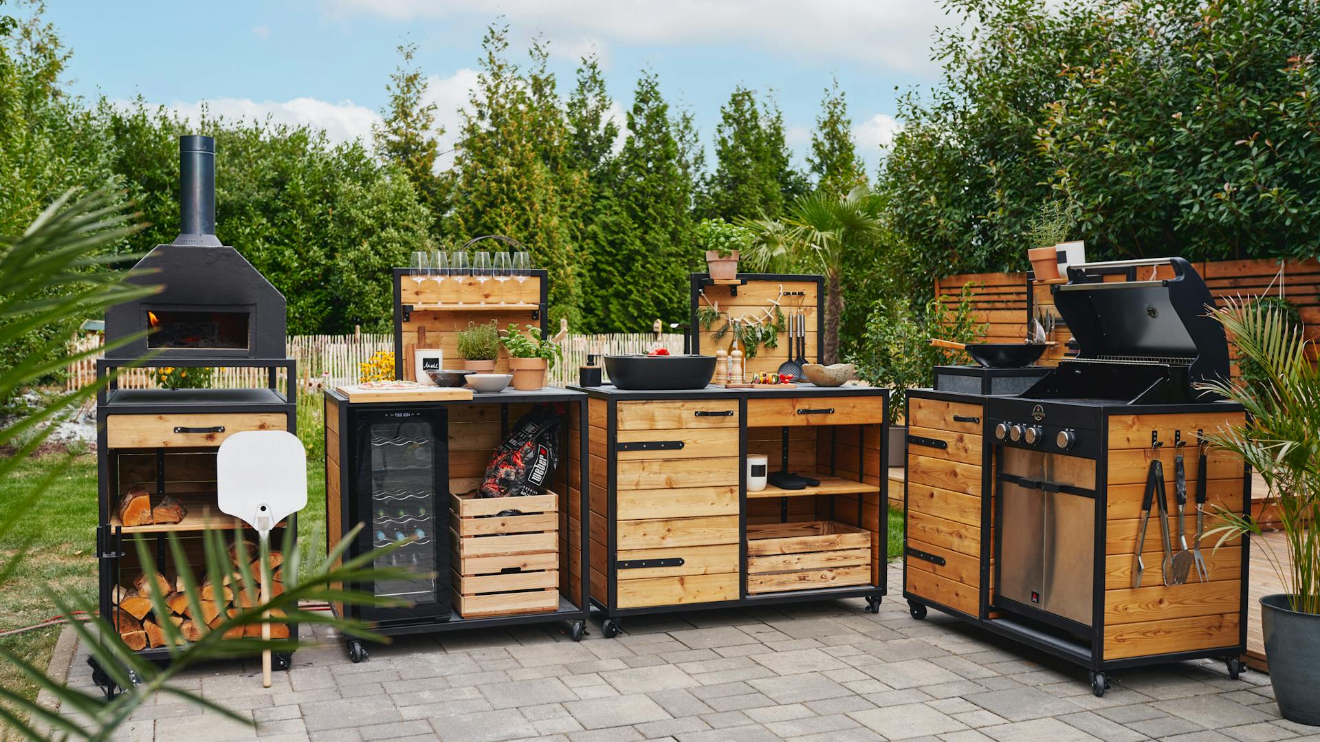 Outdoorkueche "Alfons" von den OBI Selbstbaumöbeln: Außenküche in Holz-Optik mit Waschbecken, Pizzaofen und großer Arbeitsfläche.