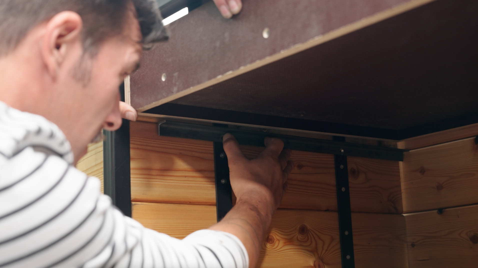 Un uomo determina la posizione della guida per il cassetto della cucina esterna.