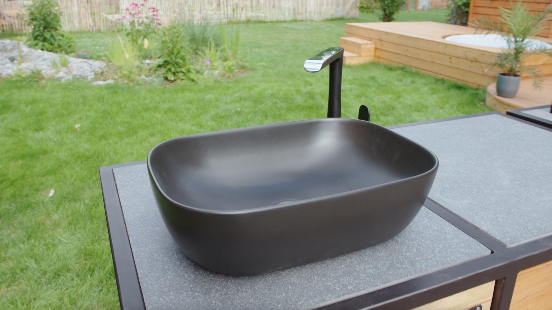 Un lavandino pronto integrato nella cucina esterna con miscelatore.