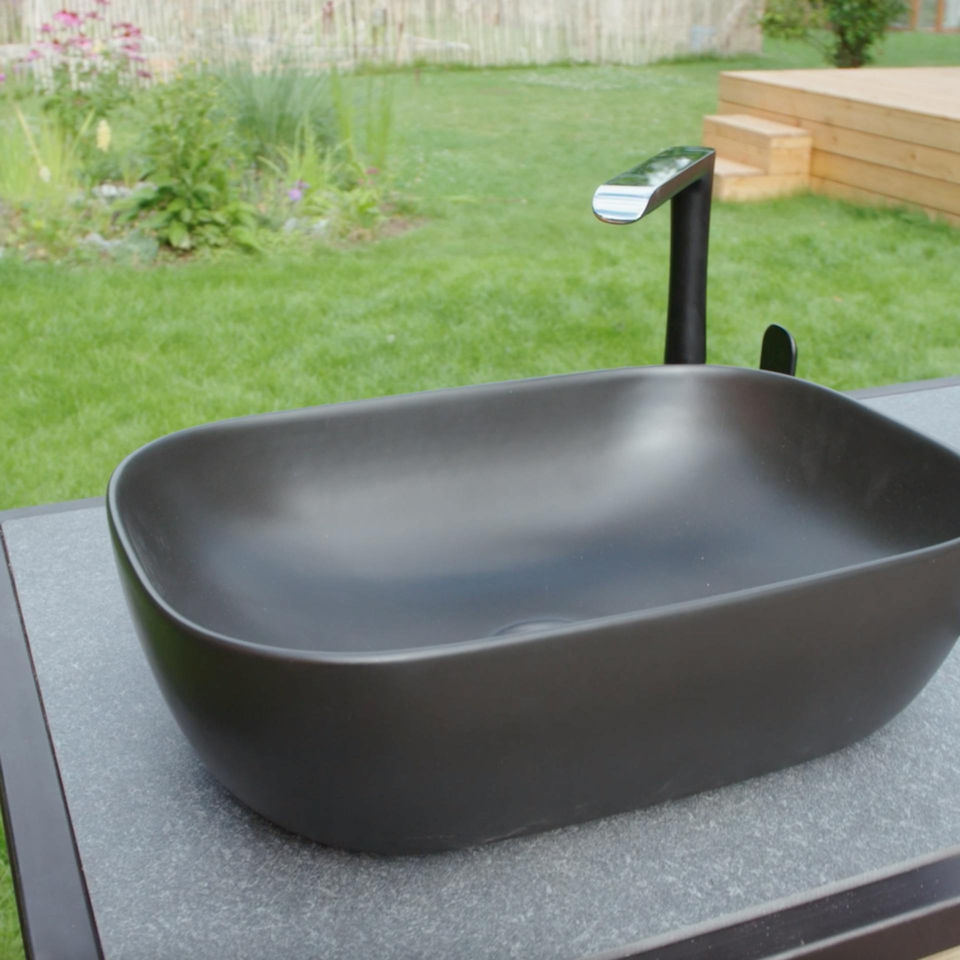 Un lavandino pronto integrato nella cucina esterna con miscelatore.