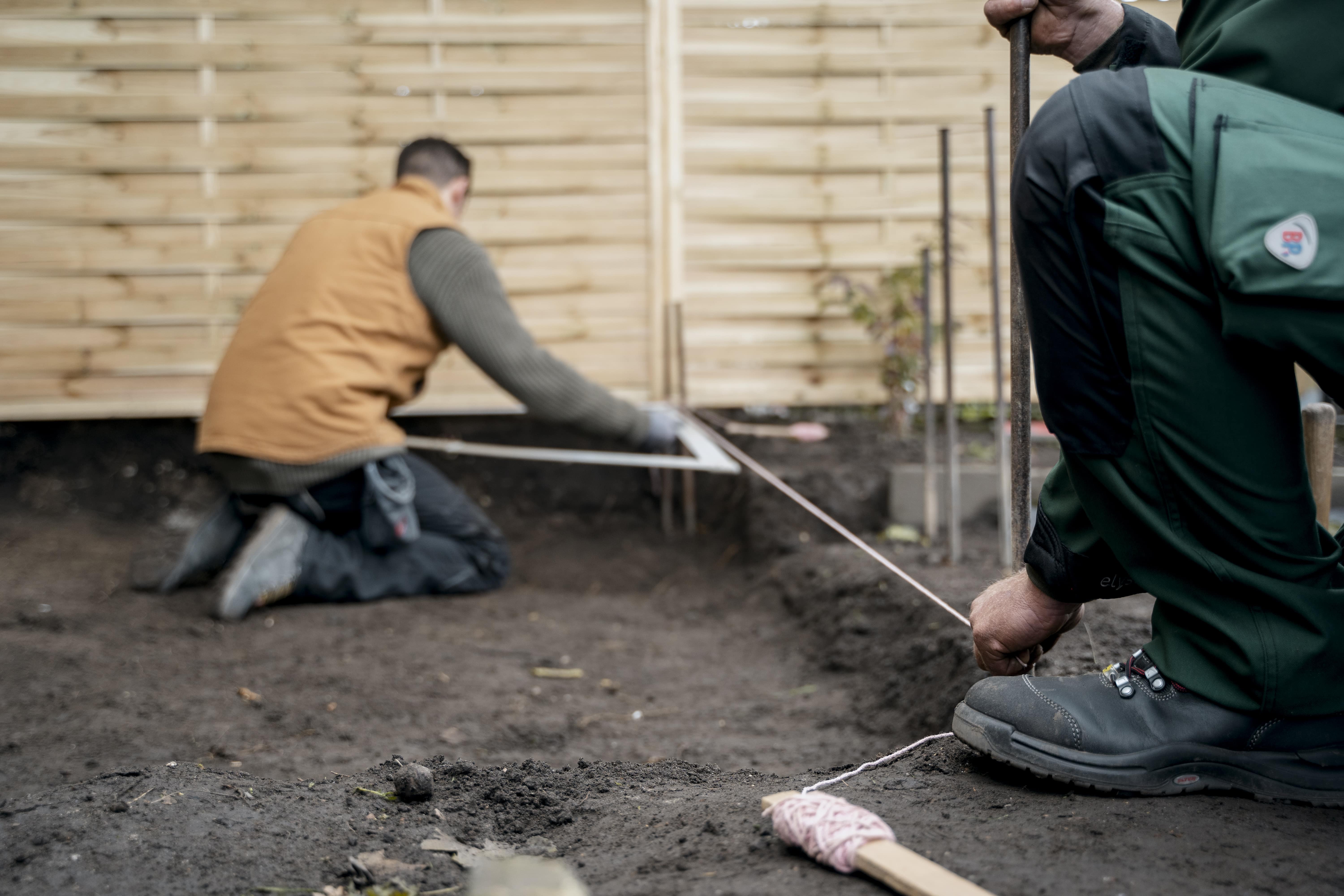 Két mesterember kiméri a területet.
