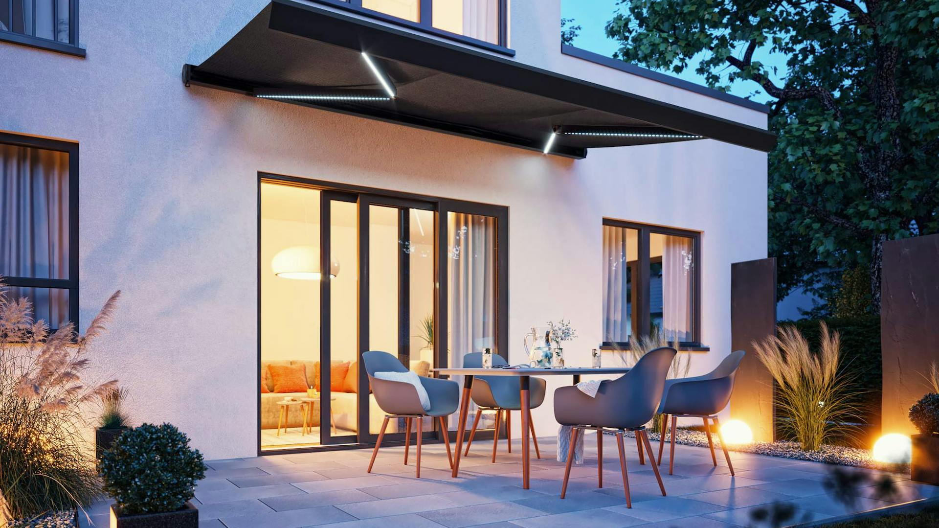 Warm beleuchtete Terrasse mit Markise bei Nacht.