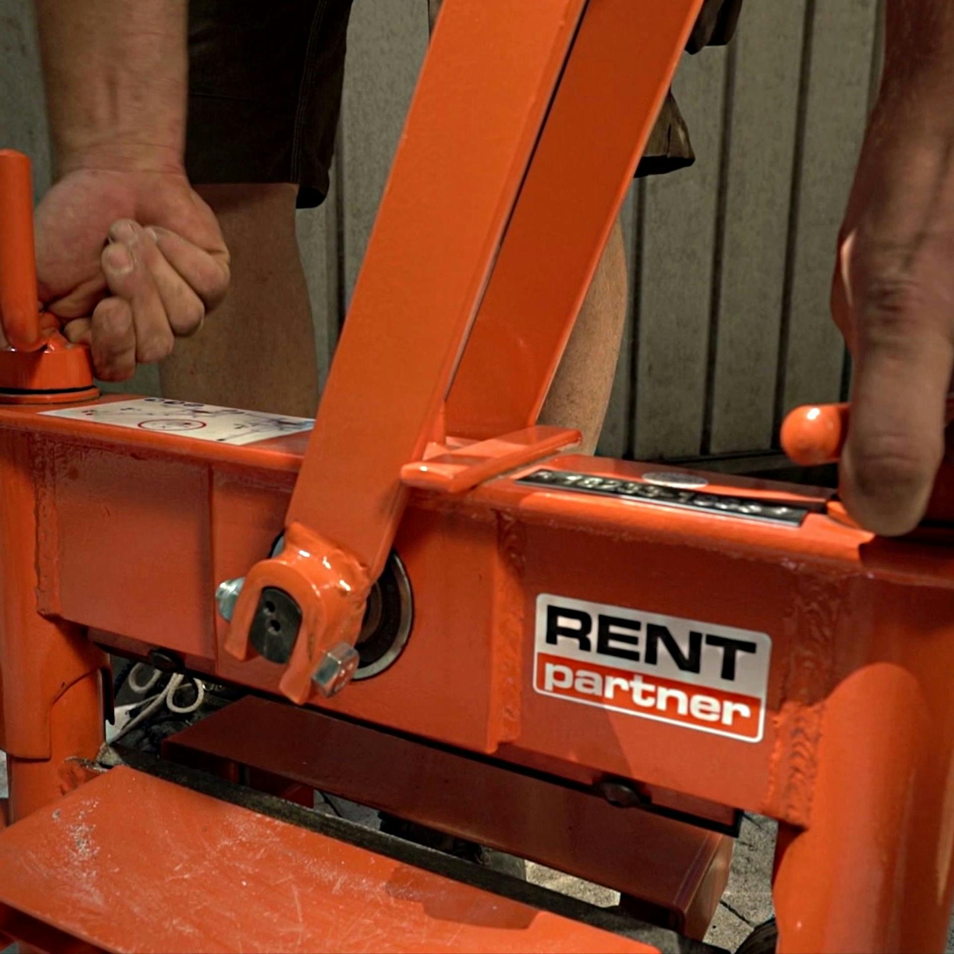 Ein Mann stellt die Höhe des Messbalkens an einem Steinschneider ein