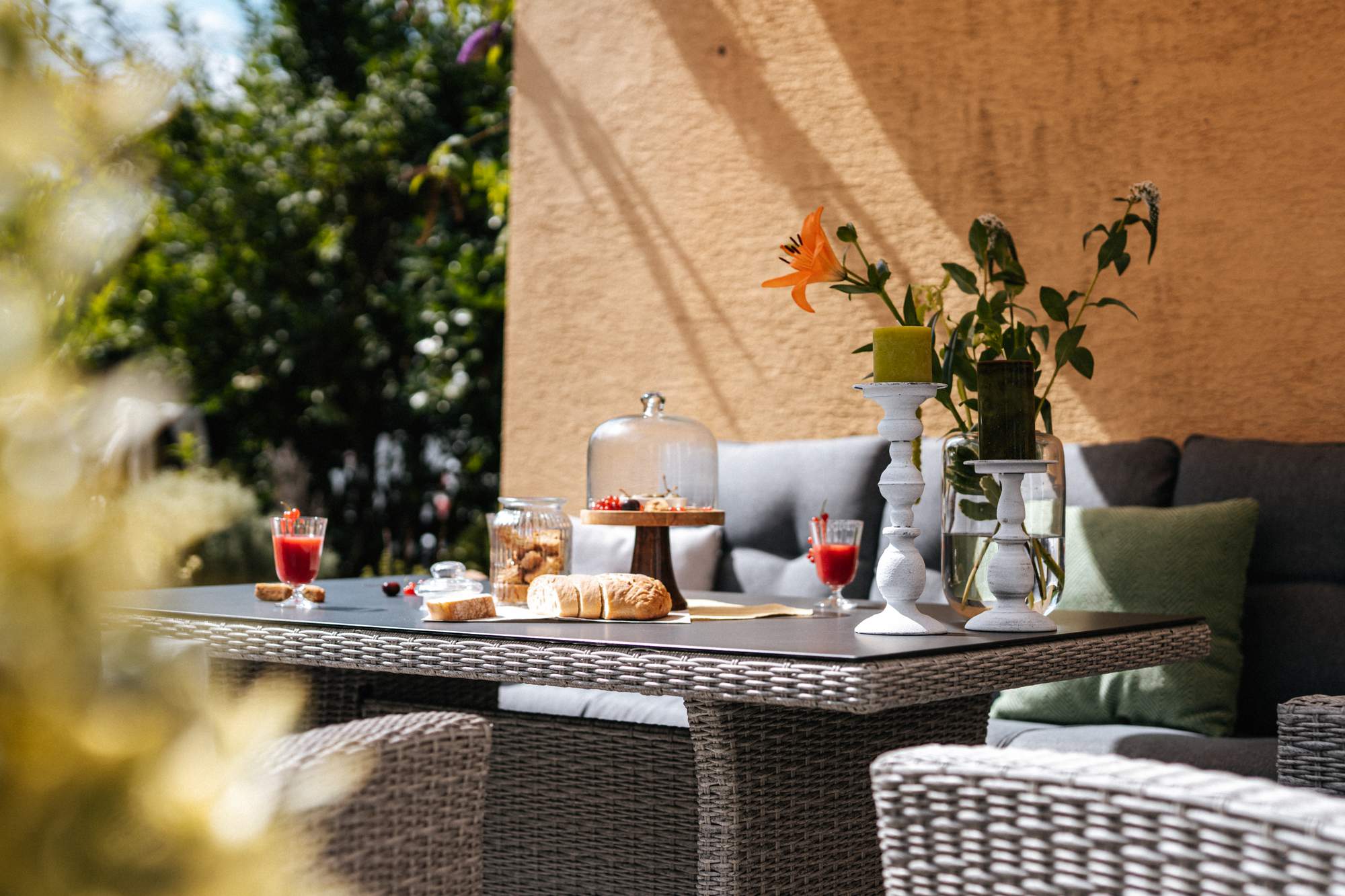 Gartentisch mit Blumen, Essen und Getränken 