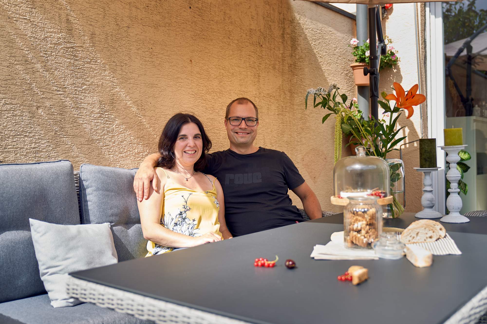 Mann und Frau sitzen an Gartentisch