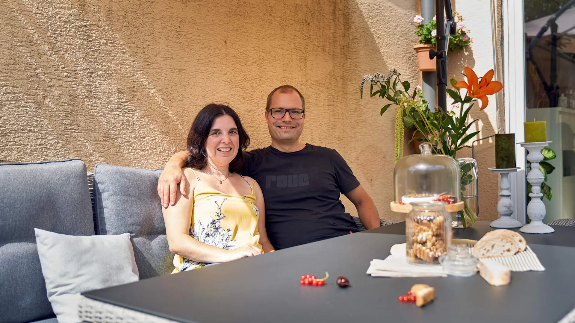 Mann und Frau sitzen an Gartentisch
