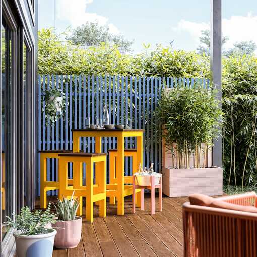 Sitzgruppe Ede für den Außenbereich steht links von Hochbeet Alfred vor einer blauen Sichtschutzwand auf einer Terrasse.