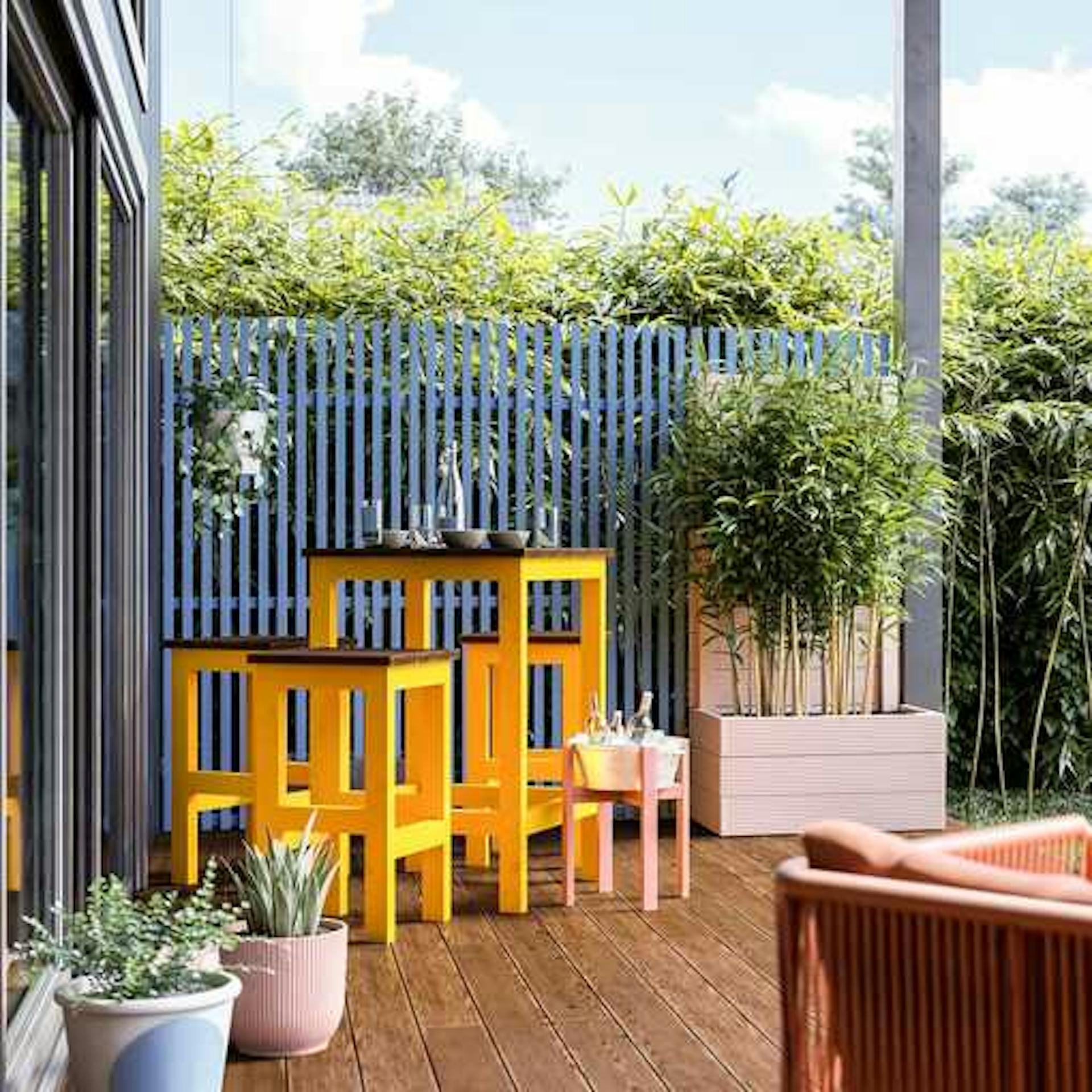 Sitzgruppe Ede für den Außenbereich steht links von Hochbeet Alfred vor einer blauen Sichtschutzwand auf einer Terrasse.