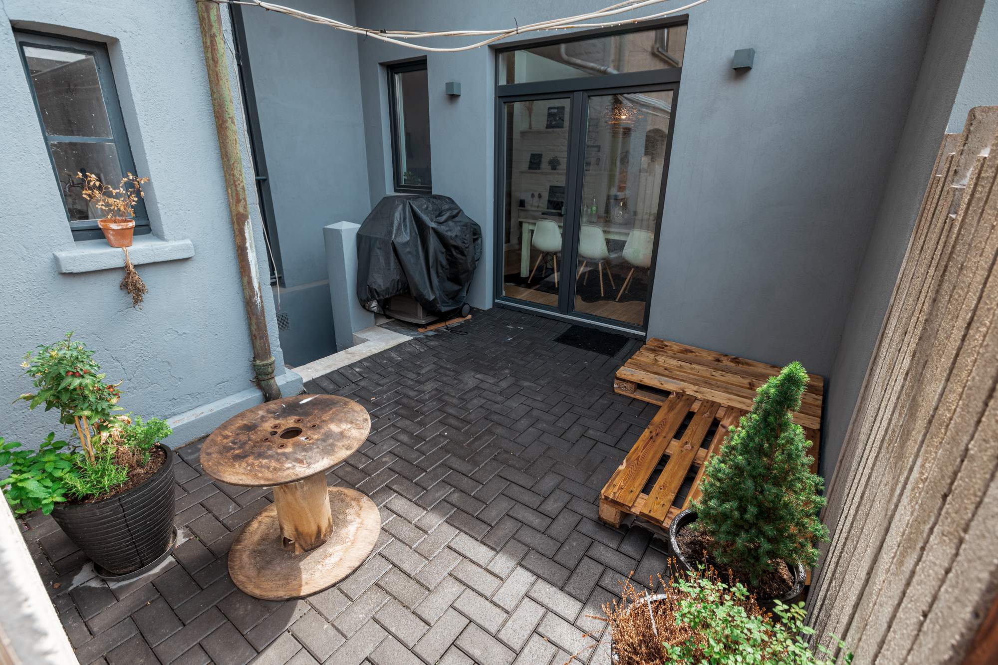 Leere Terrasse mit Paletten und Grill