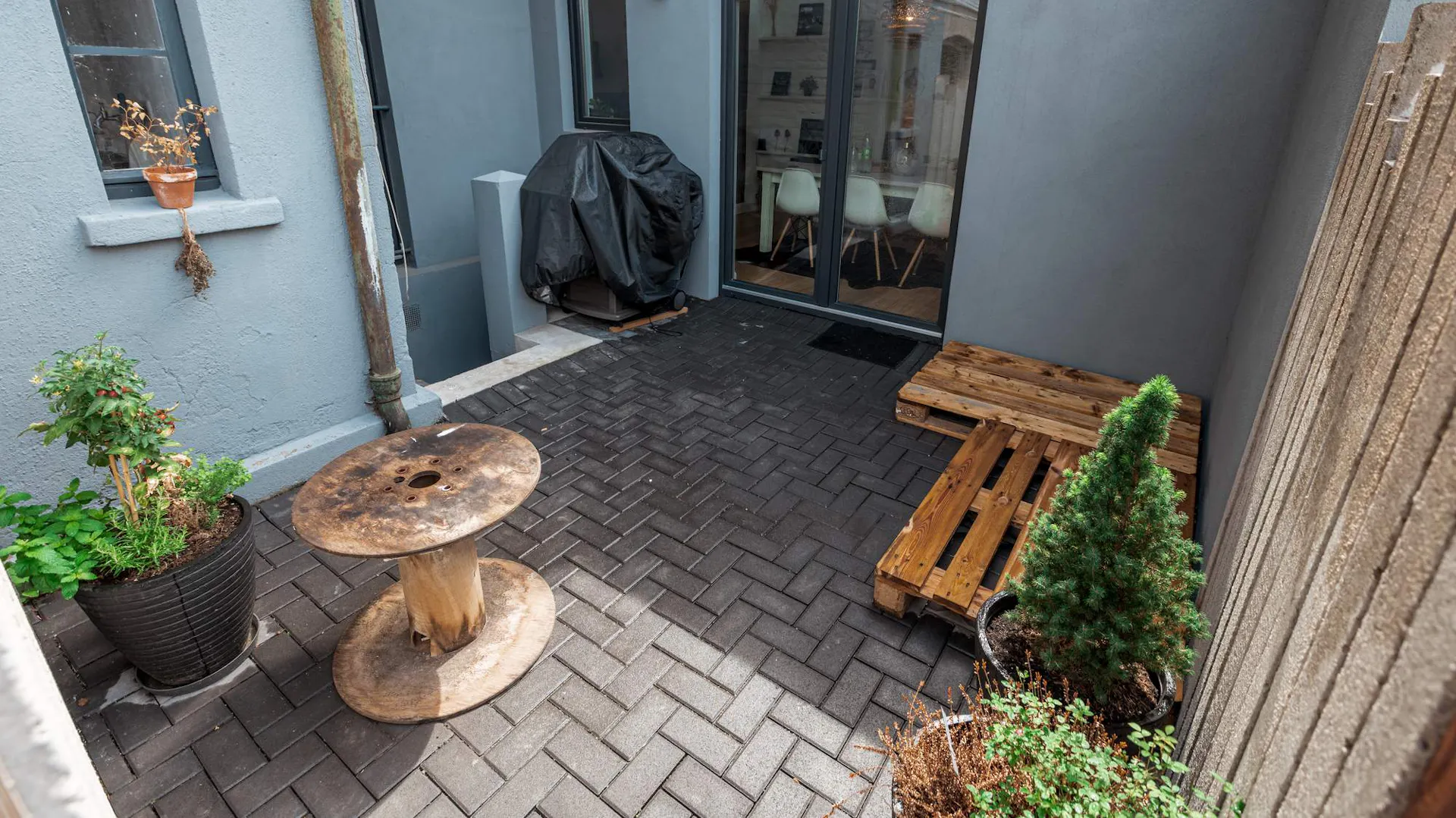 Leere Terrasse mit Paletten und Grill