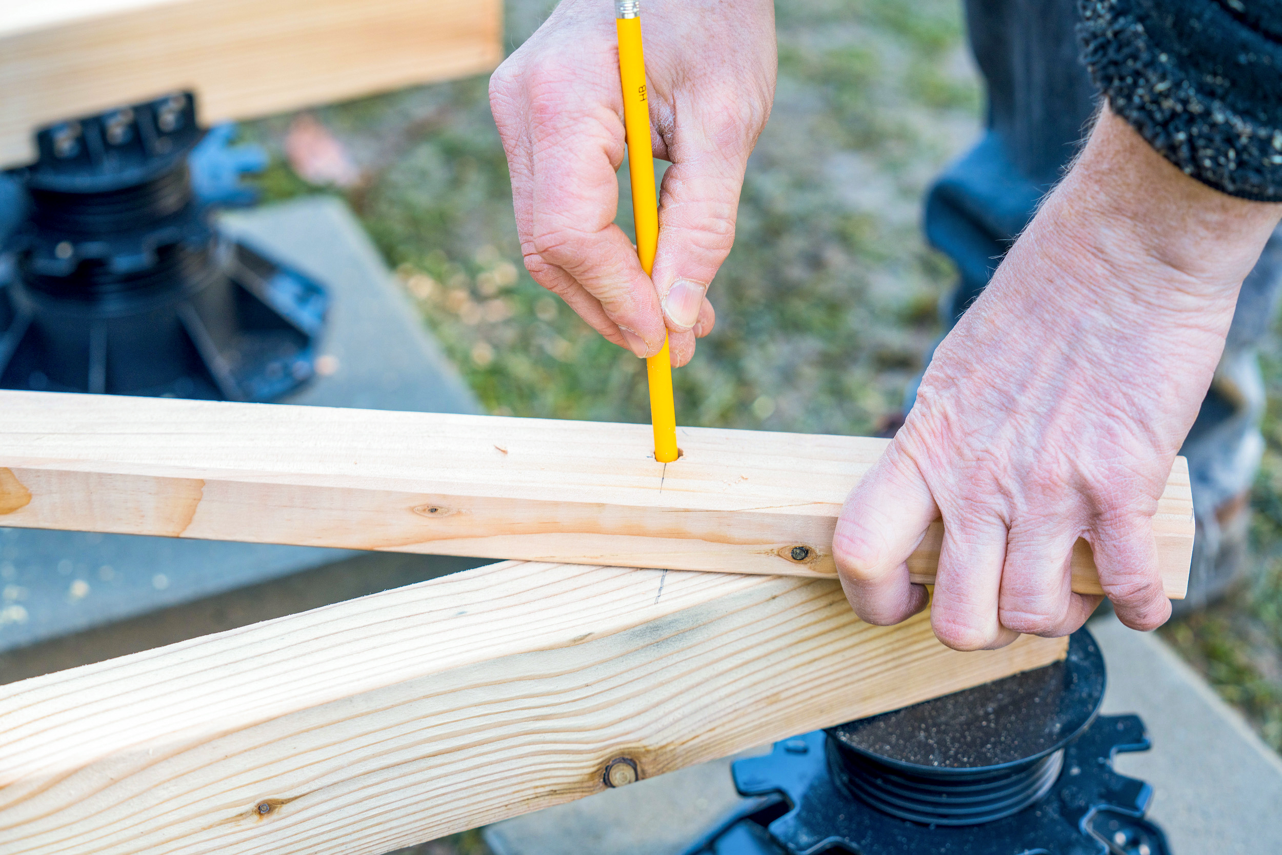 Disegnano delle mani con un compasso su una trave di legno