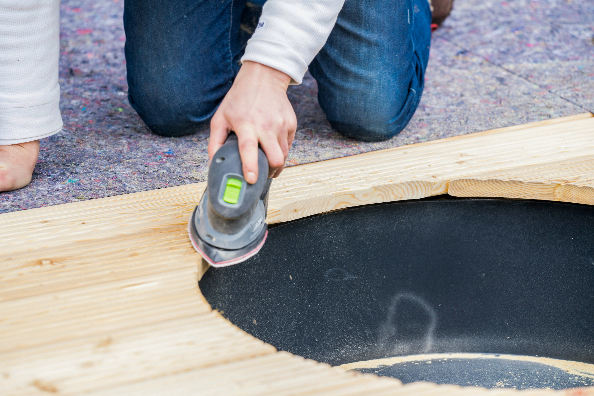 Una mano leviga i bordi delle assi per terrazza.