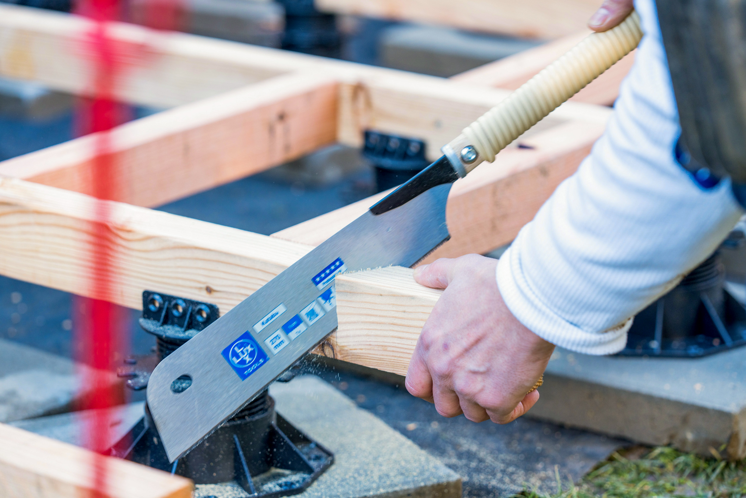 Una trave di legno viene segata con una sega giapponese