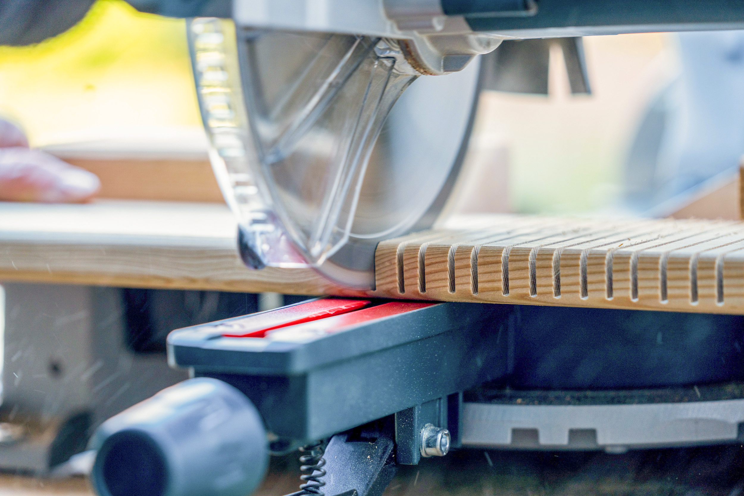 Una troncatrice taglia in una tavola di legno.