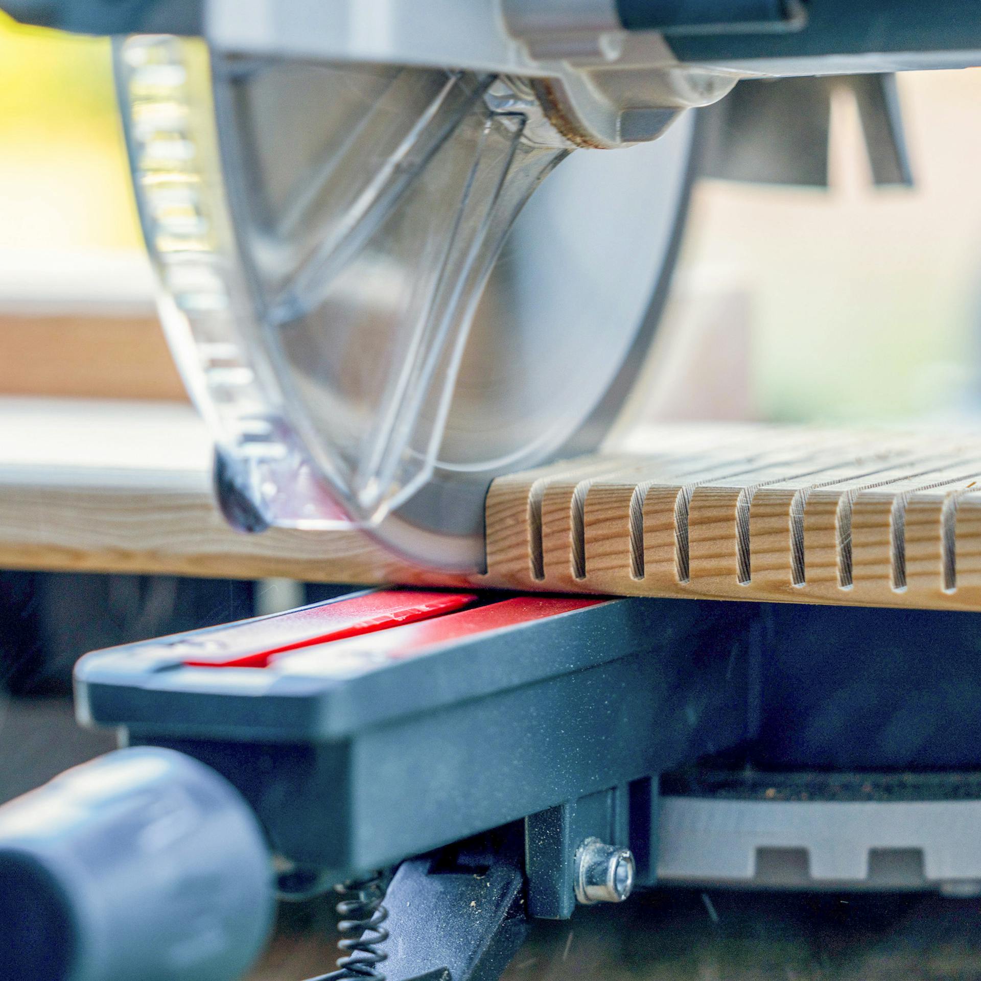 Eine Kappsäge schneidet in ein Holzbrett.