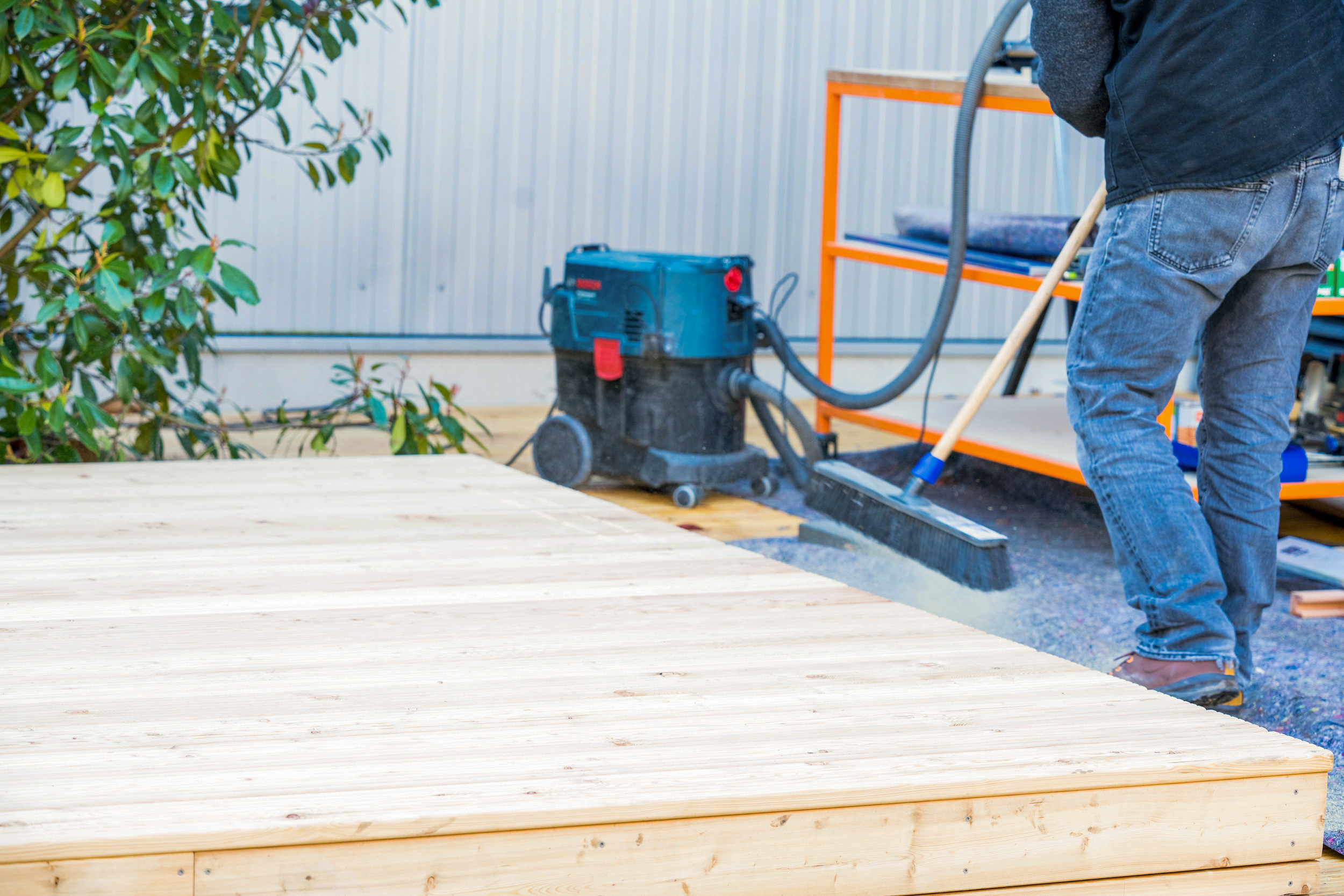 Un uomo pulisce una terrazza.