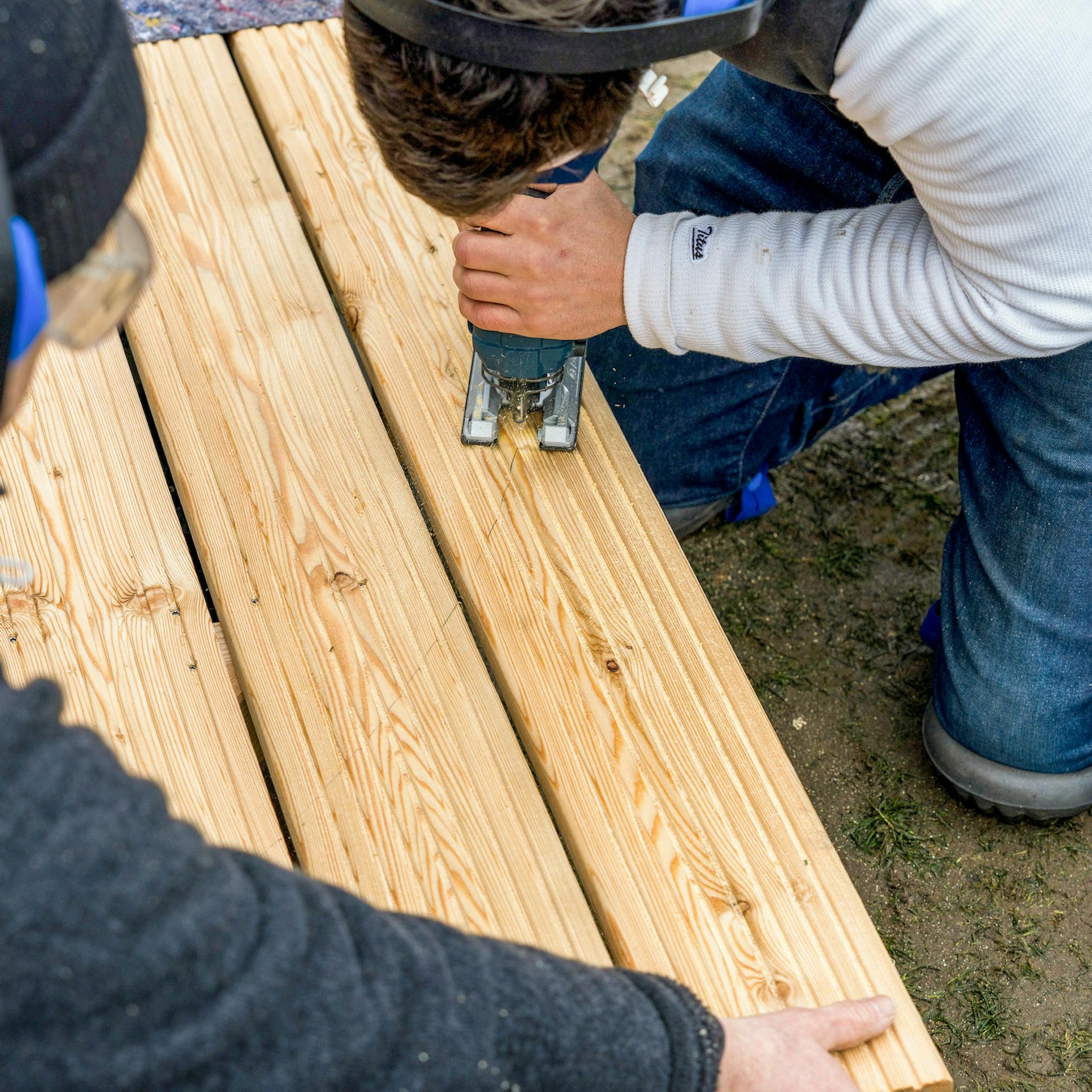 Terrassendielen werden ausgesägt.