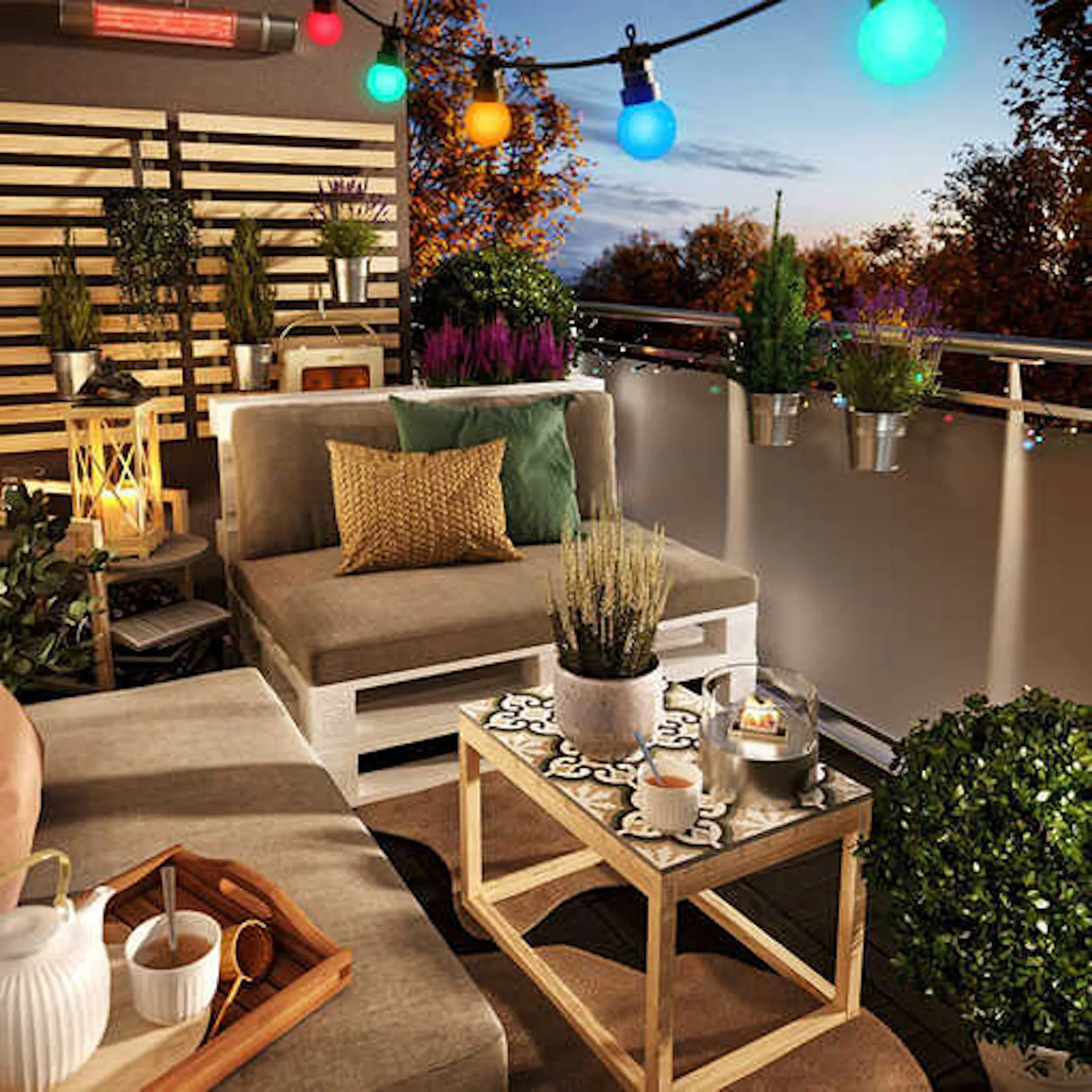 Palettencouch Bankig steht auf einem Balkon der mit Lichterketten geschmückt ist und der eine Sprossenwand besitzt an den Pflanzen aufgehängt sind