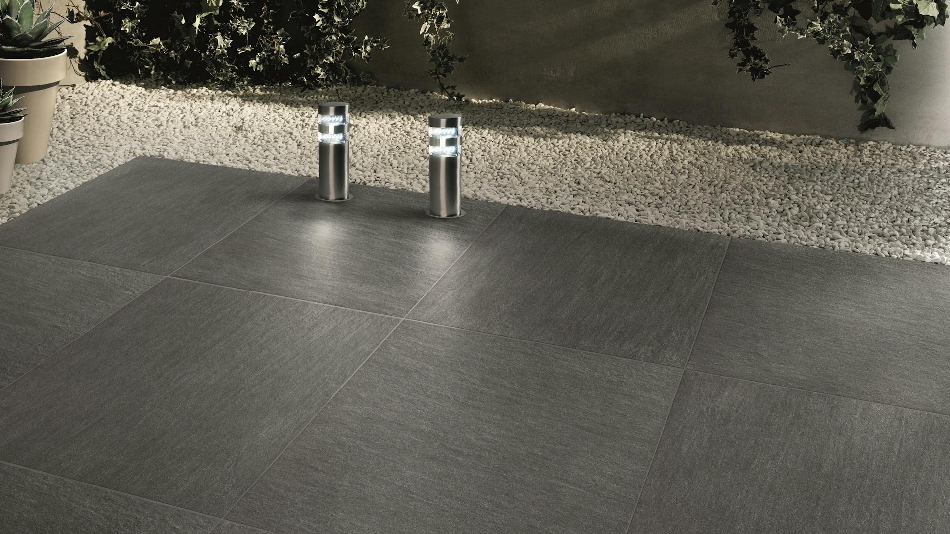 Dunkle Terrassenfliesen aus Feinsteinzeug verlegt mit Einfassung