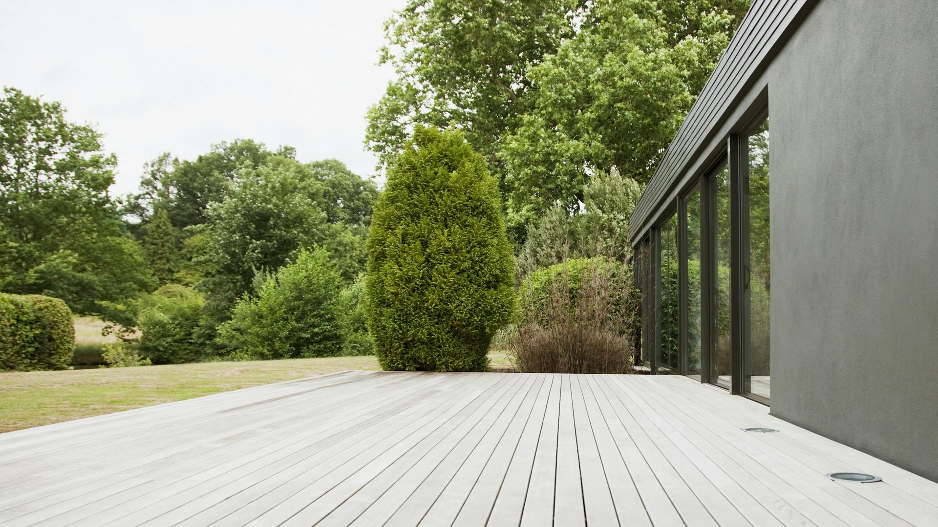 Eine große Holzterrasse vor einem modernen Haus.