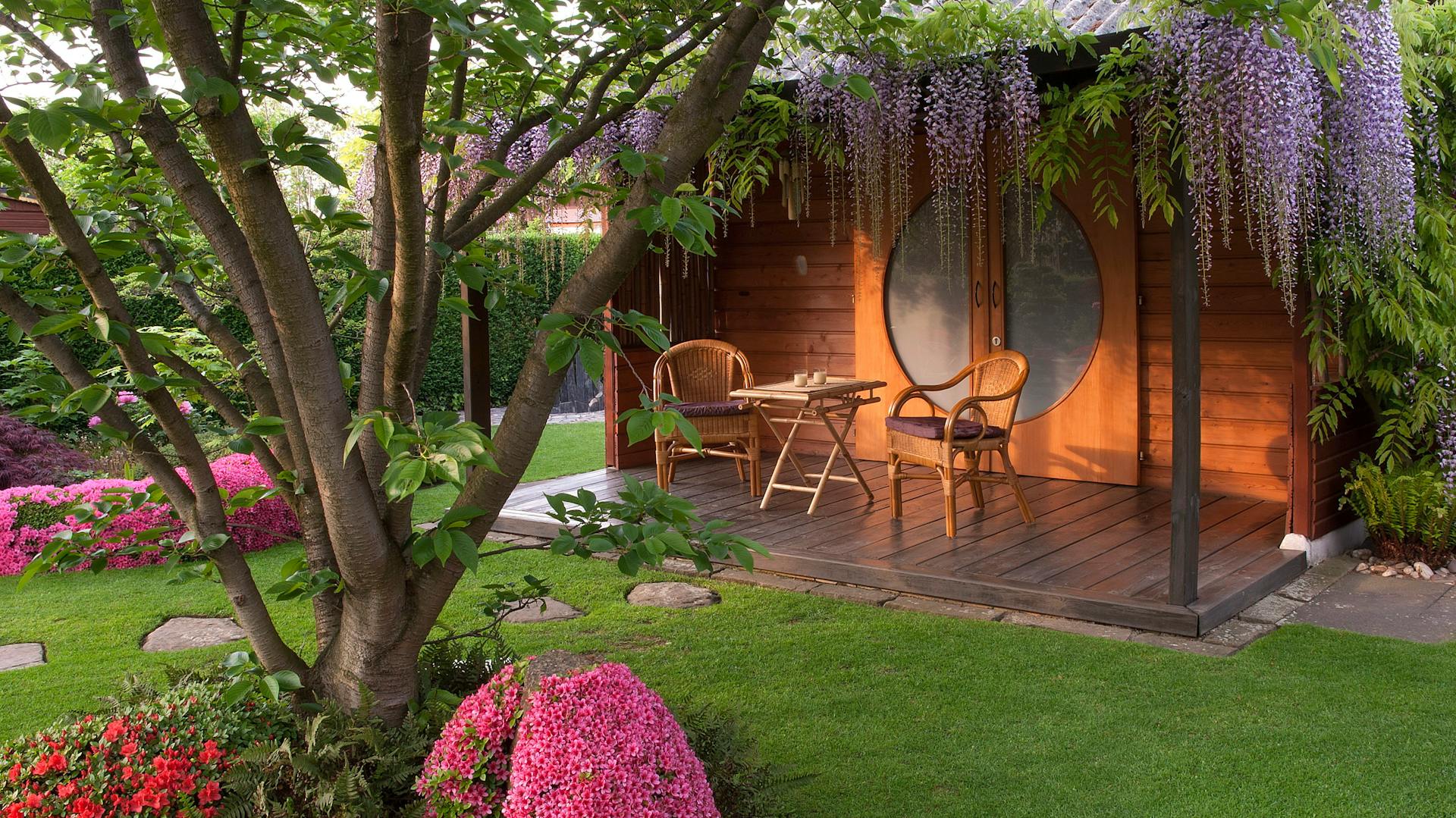 Una piccola terrazza in legno con sedie e un tavolo.