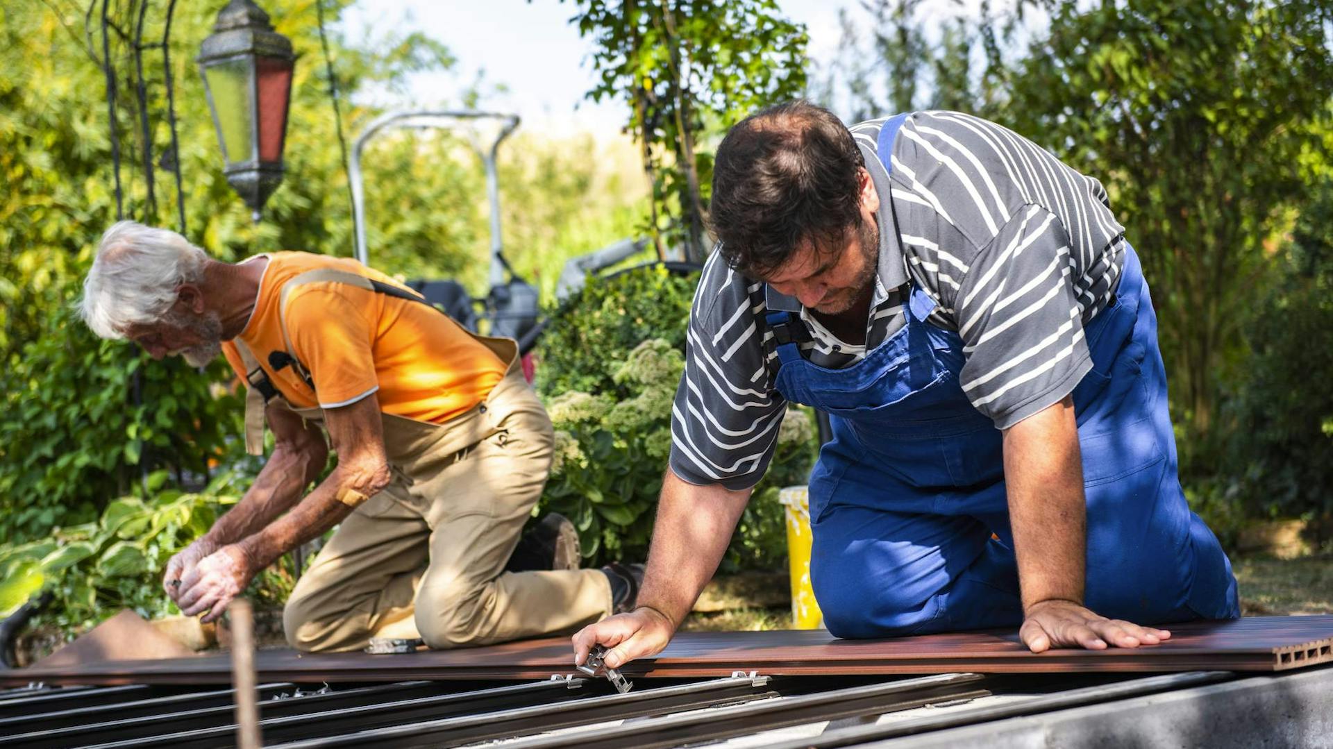 Zwei Männer befestigen WPC-Dielen auf der Unterkonstruktion