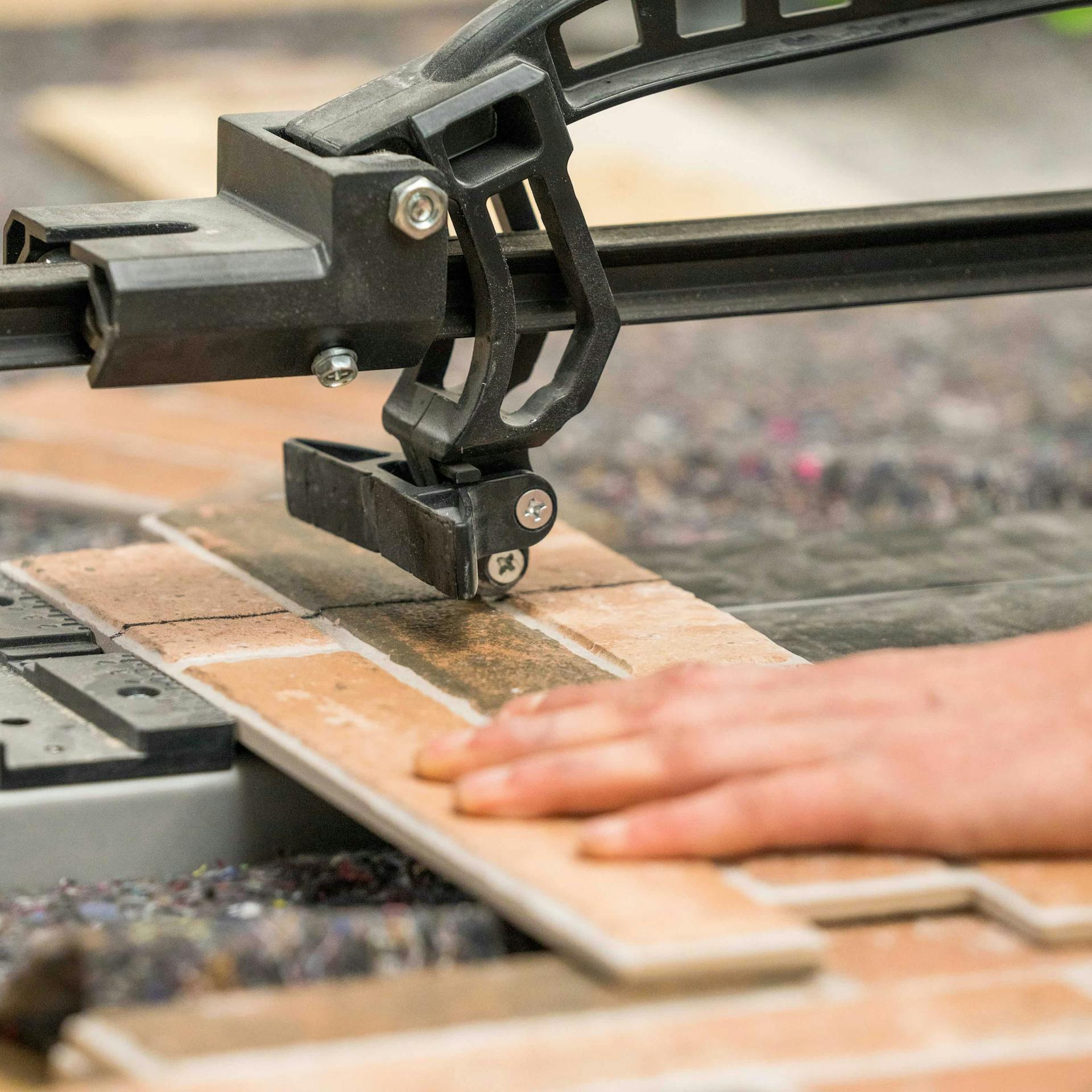 Ein FSZ-Verblender wird mit einem Fliesenschneider zugeschnitten.