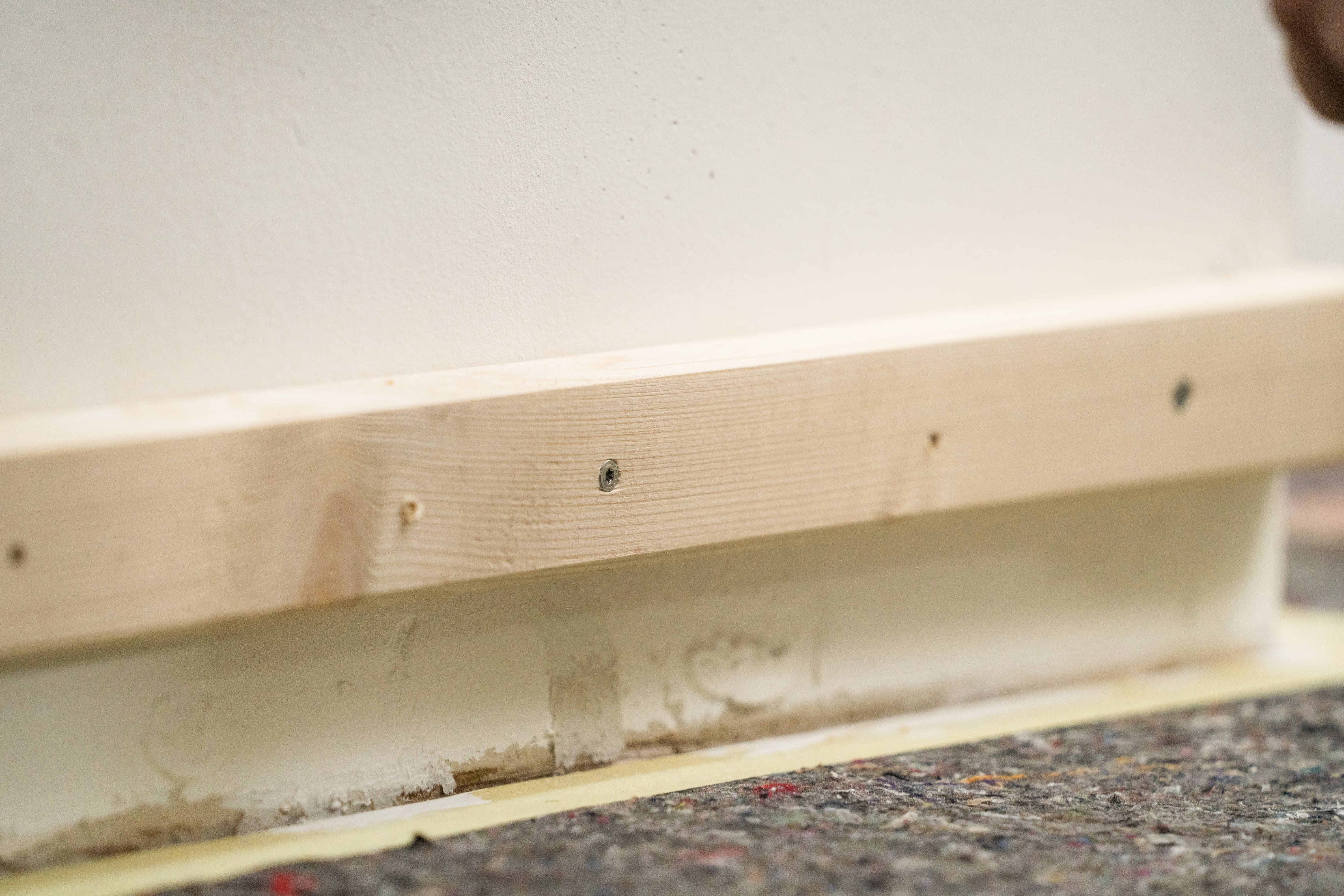 Eine Hilfslatte aus Holz an einer Wand.