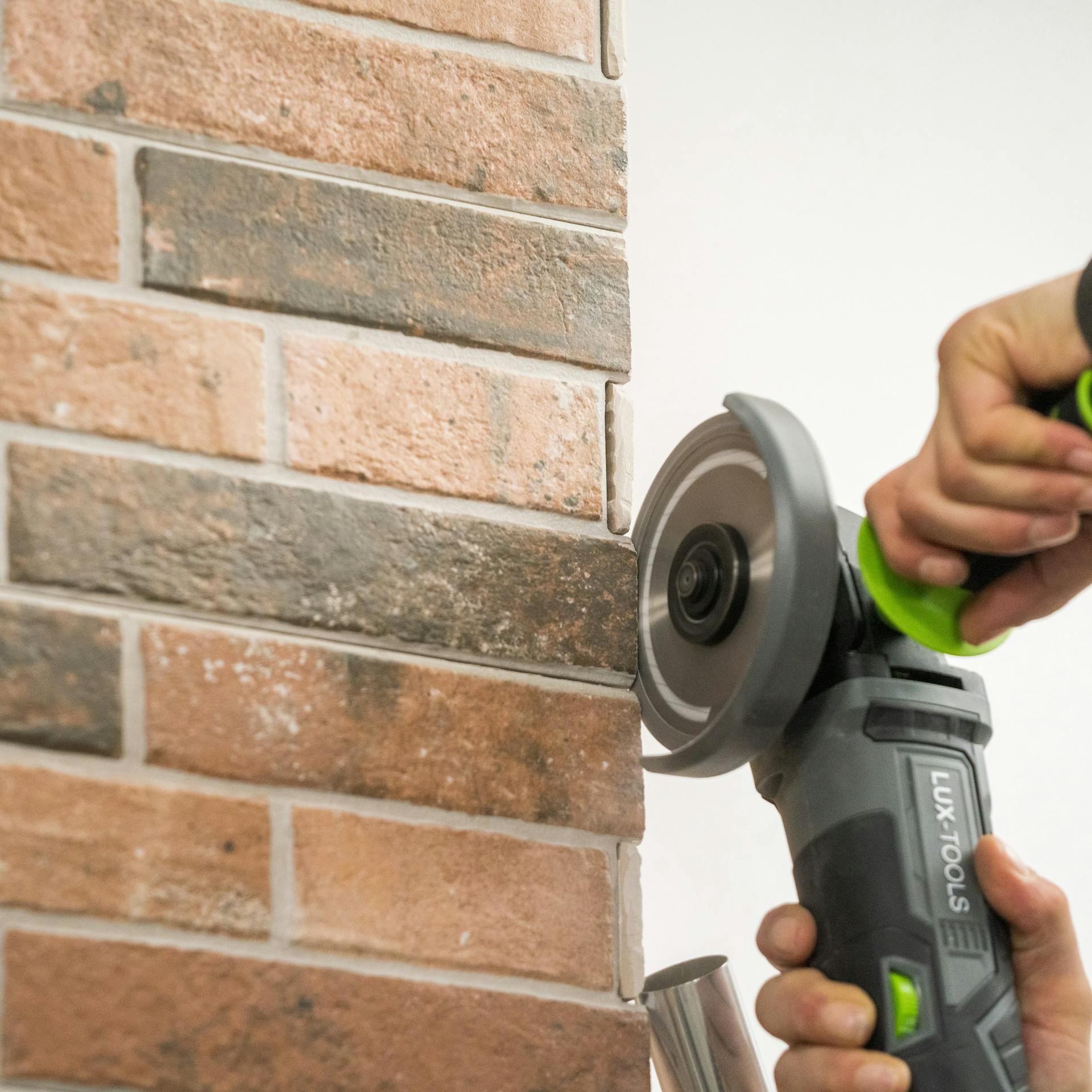 Heimwerker schleift scharfe Kanten von Verblendern ab.