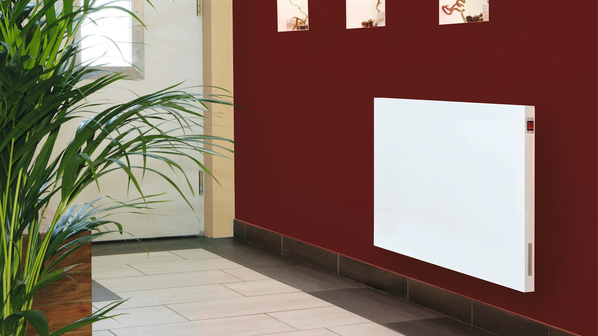 Lapradiátor a falon egy sötétvörös, dekorált folyosón