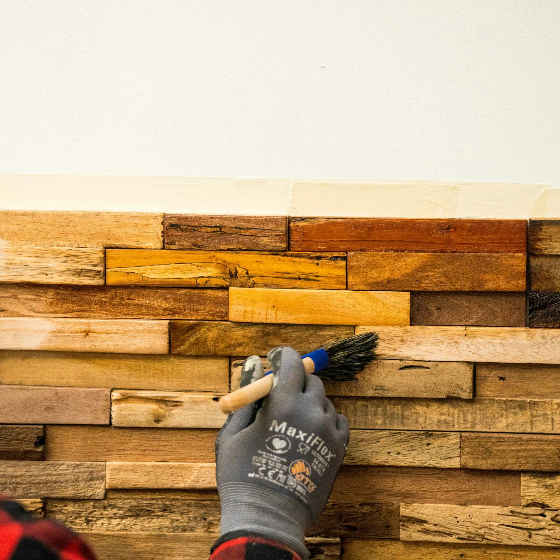 Jemand ölt Holzverblender mit Holzöl.