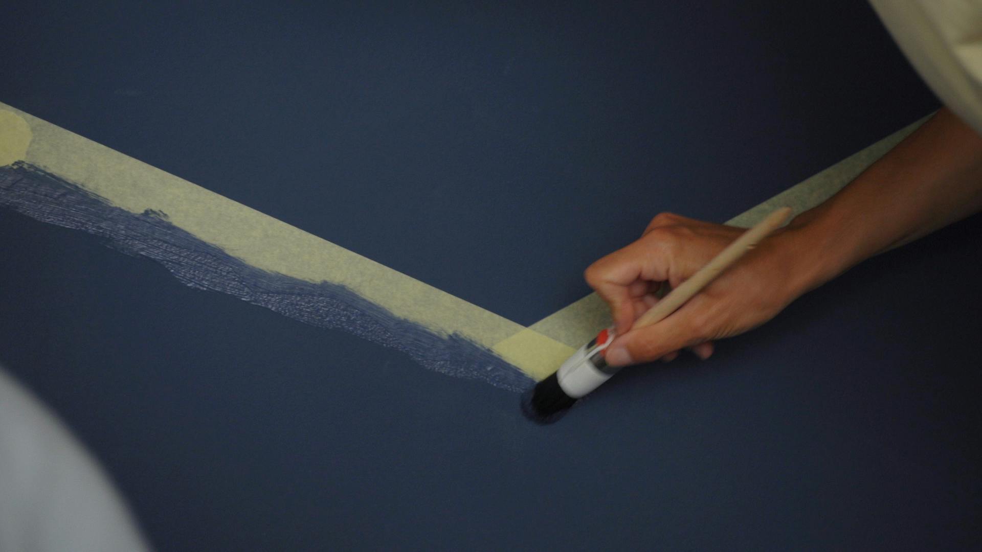 Dipingere le porzioni di parete mascherate con il nastro per disegnare il motivo di montagna