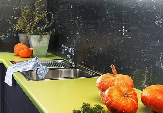 Smalto effetto lavagna sulla parete della cucina dietro il lavello e il piano di lavoro.