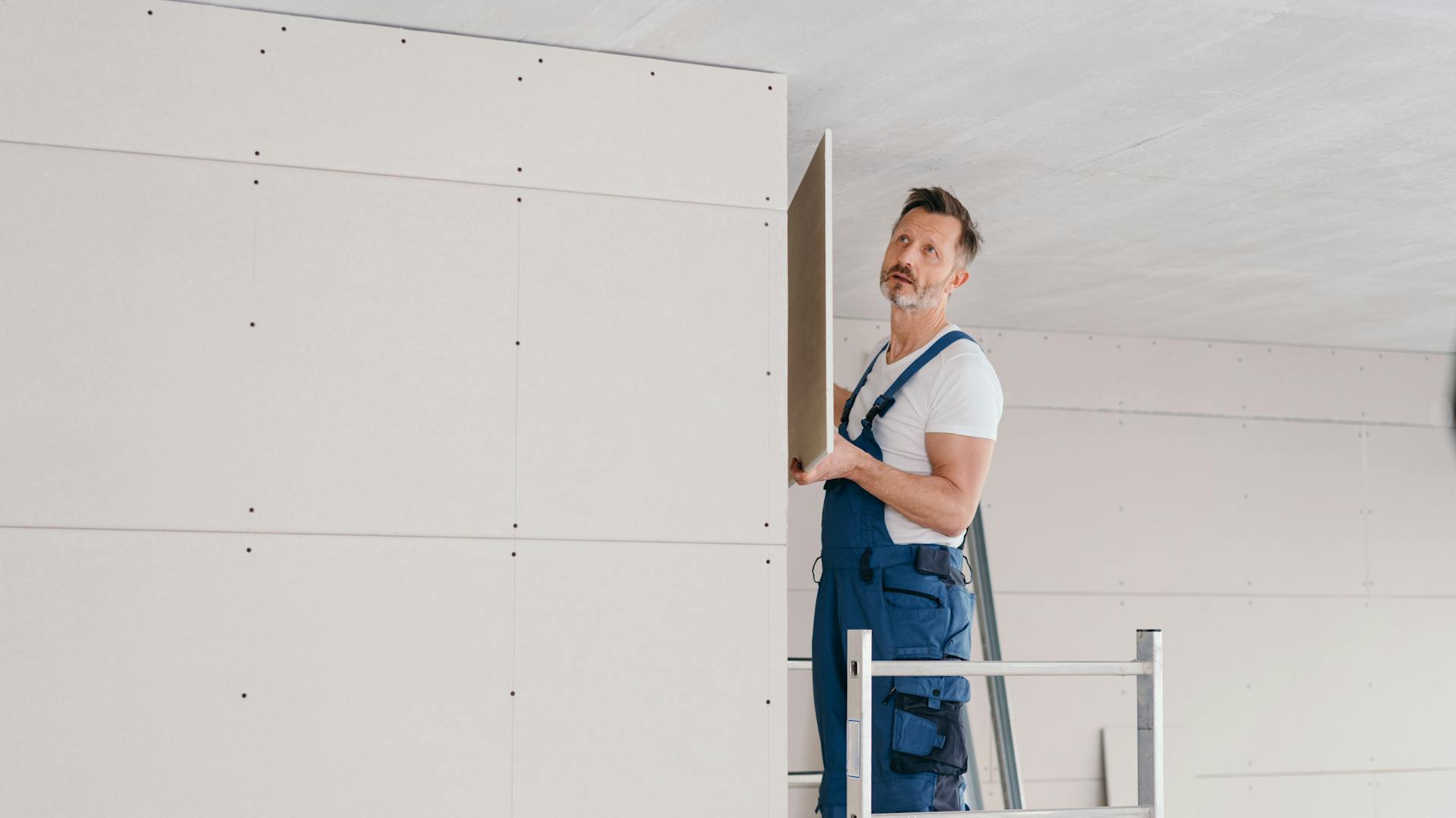 Ein Mann installiert eine Montagewand für den Trockenbau.