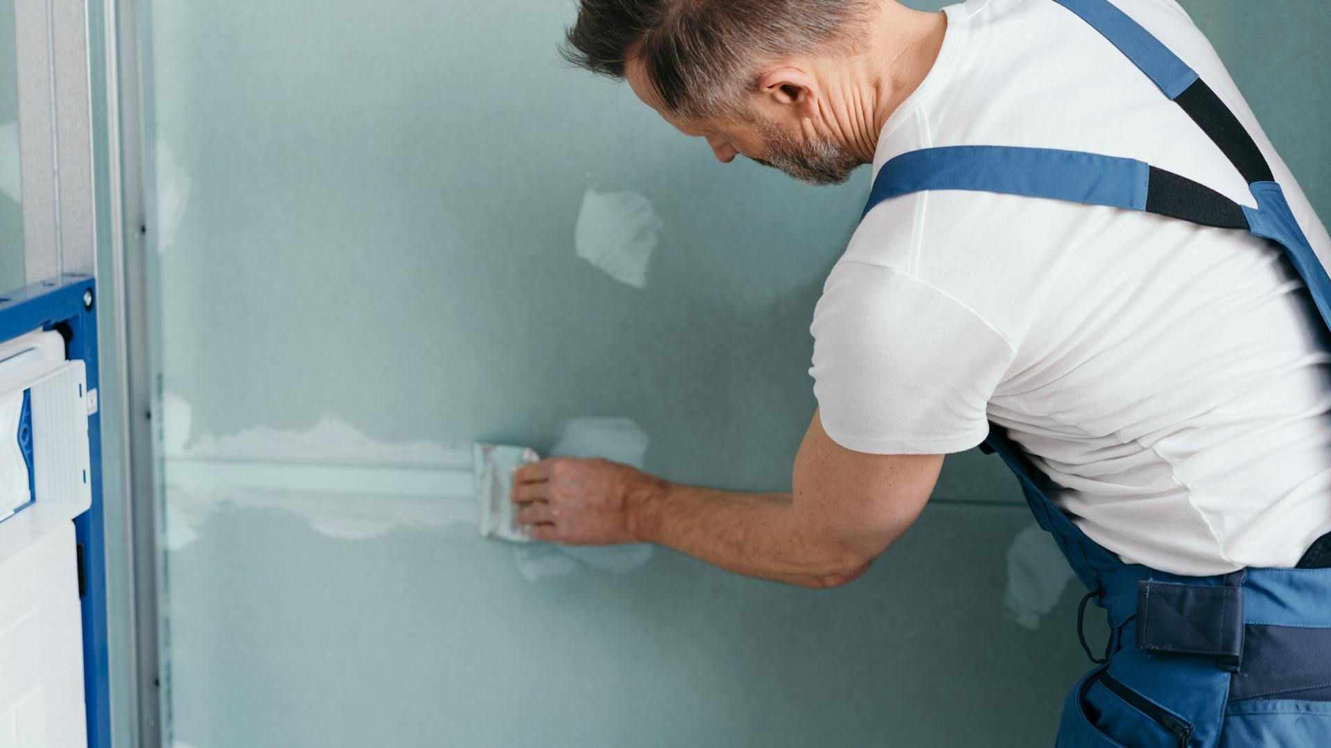 Ein Mann verputzt Trockenbauelemente.