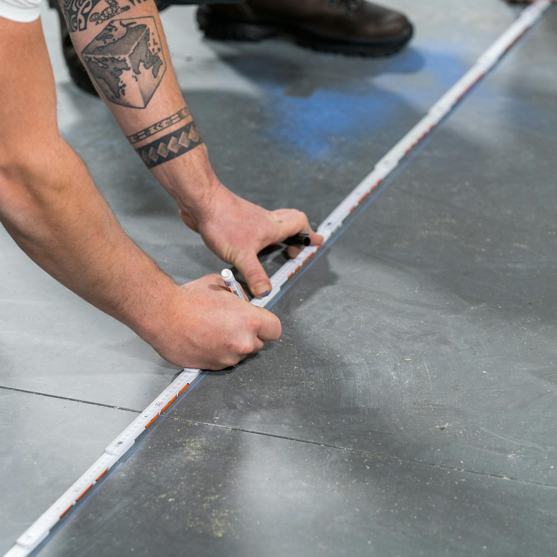 Heimwerker legt den Wandverlauf auf den Boden fest.
