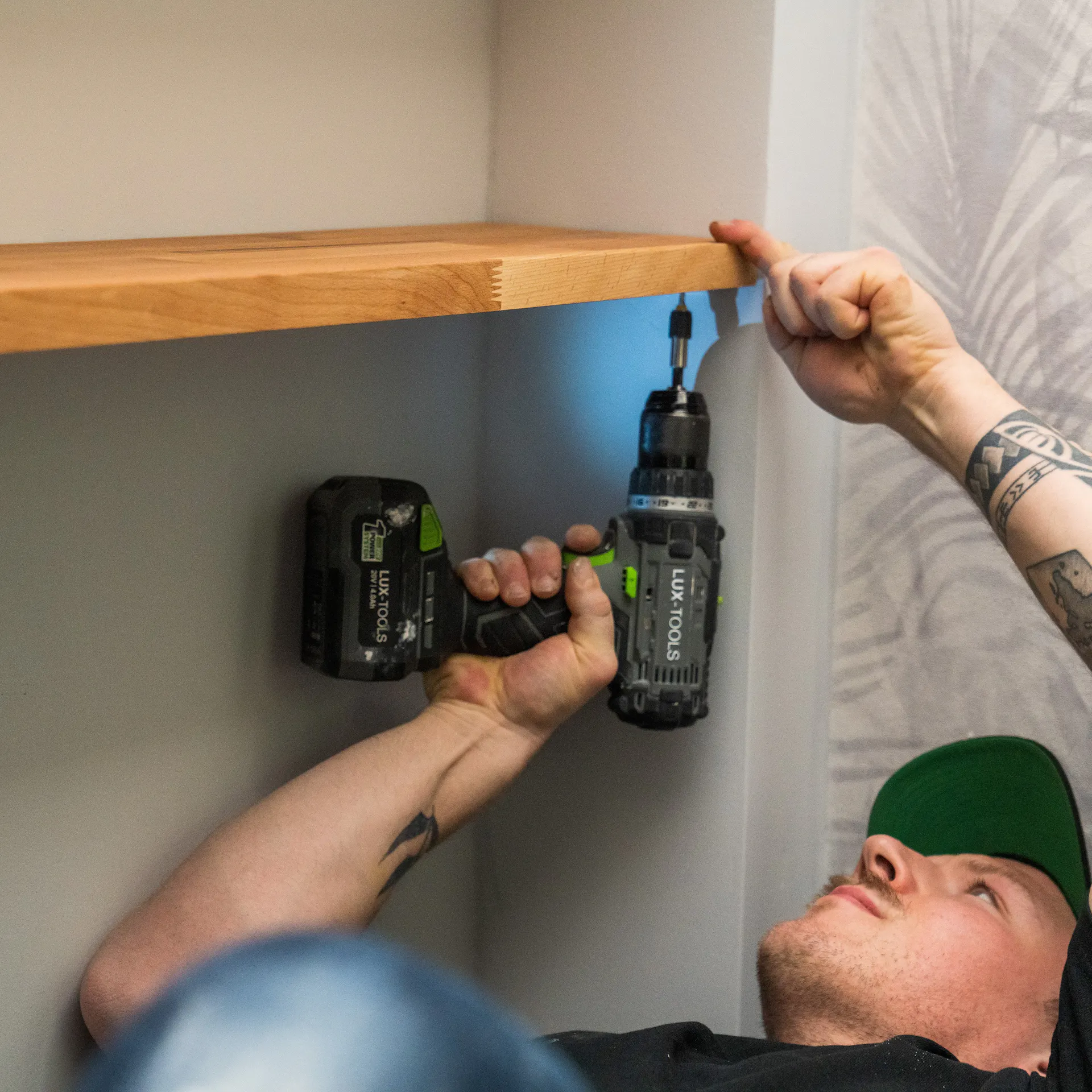 Handwerker schraubt das Brett an die Porenbetonwand.
