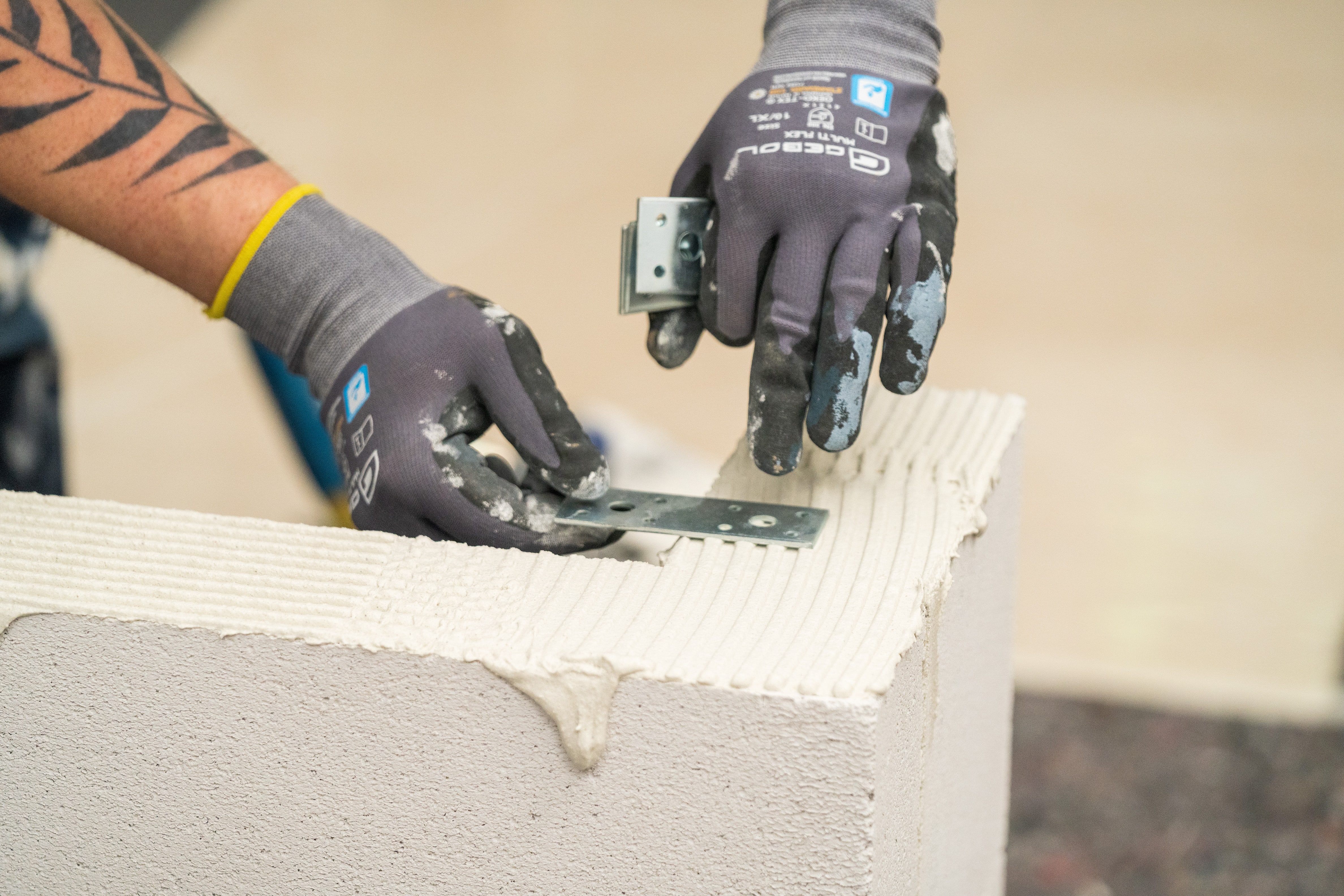 Handwerker setzt Flacheisen in den Mörtel.