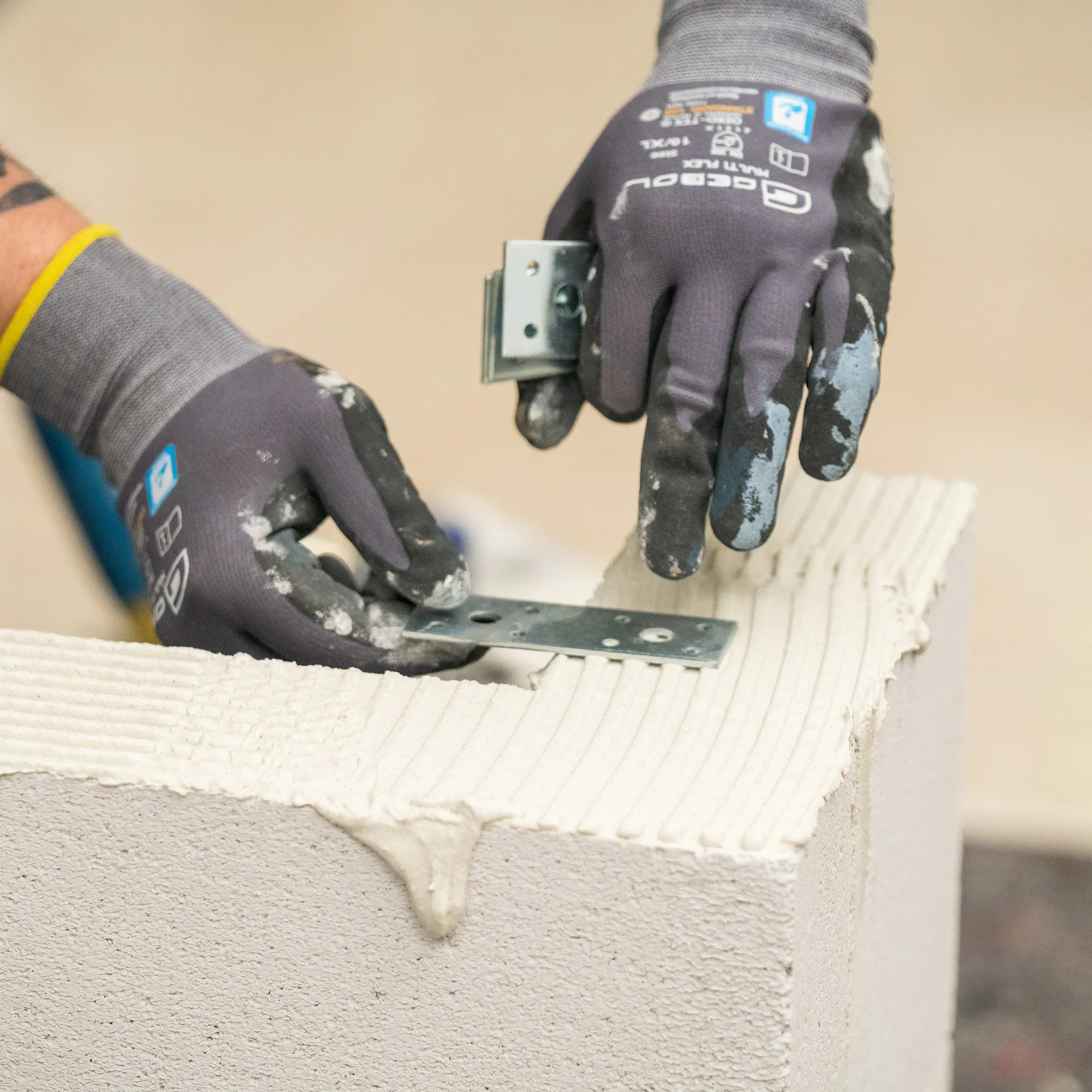 Handwerker setzt Flacheisen in den Mörtel.