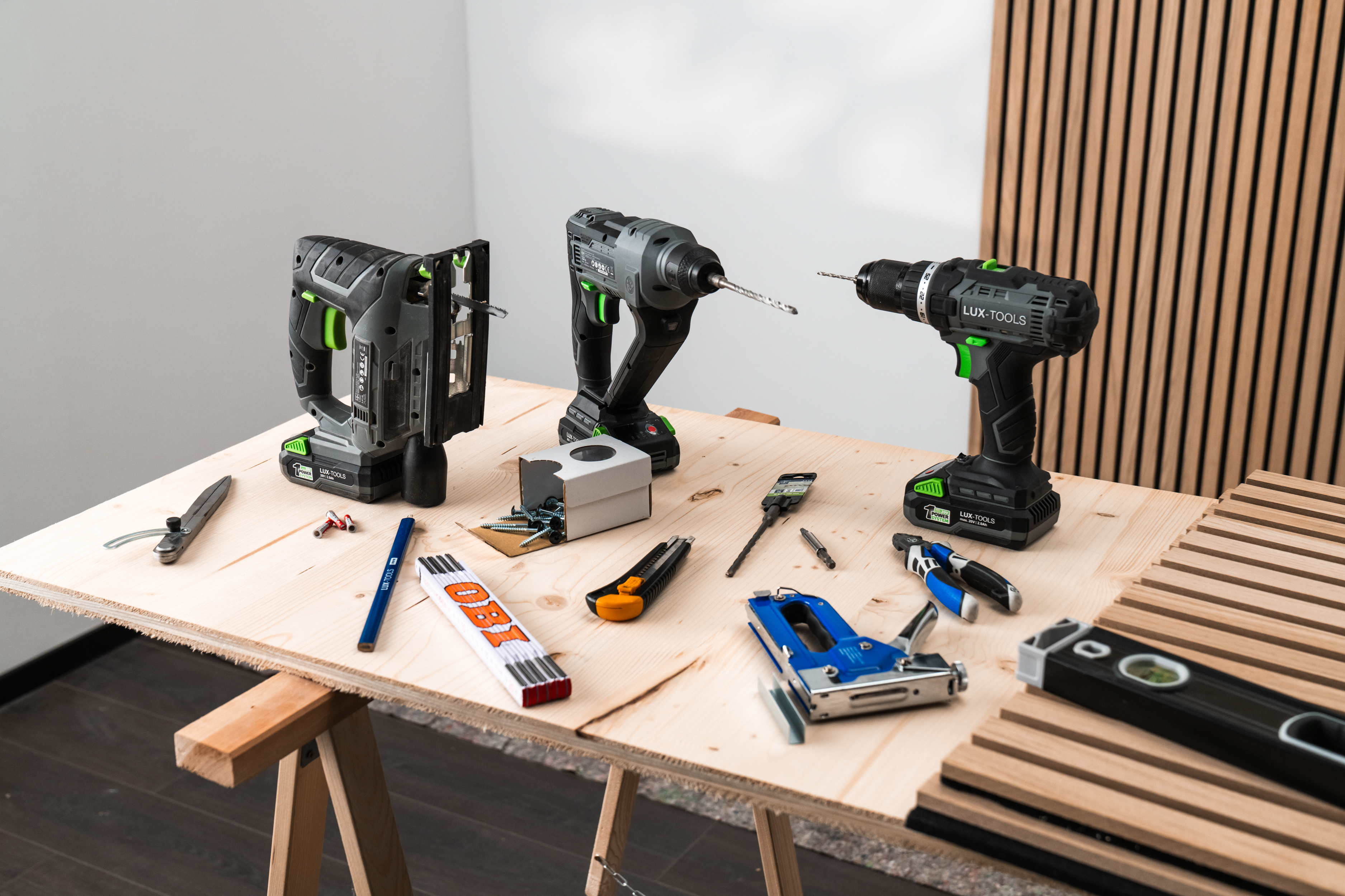 Die Materialien für die Wandgestaltung mit Akustikpaneelen stehen nebeneinander auf einem Tisch.