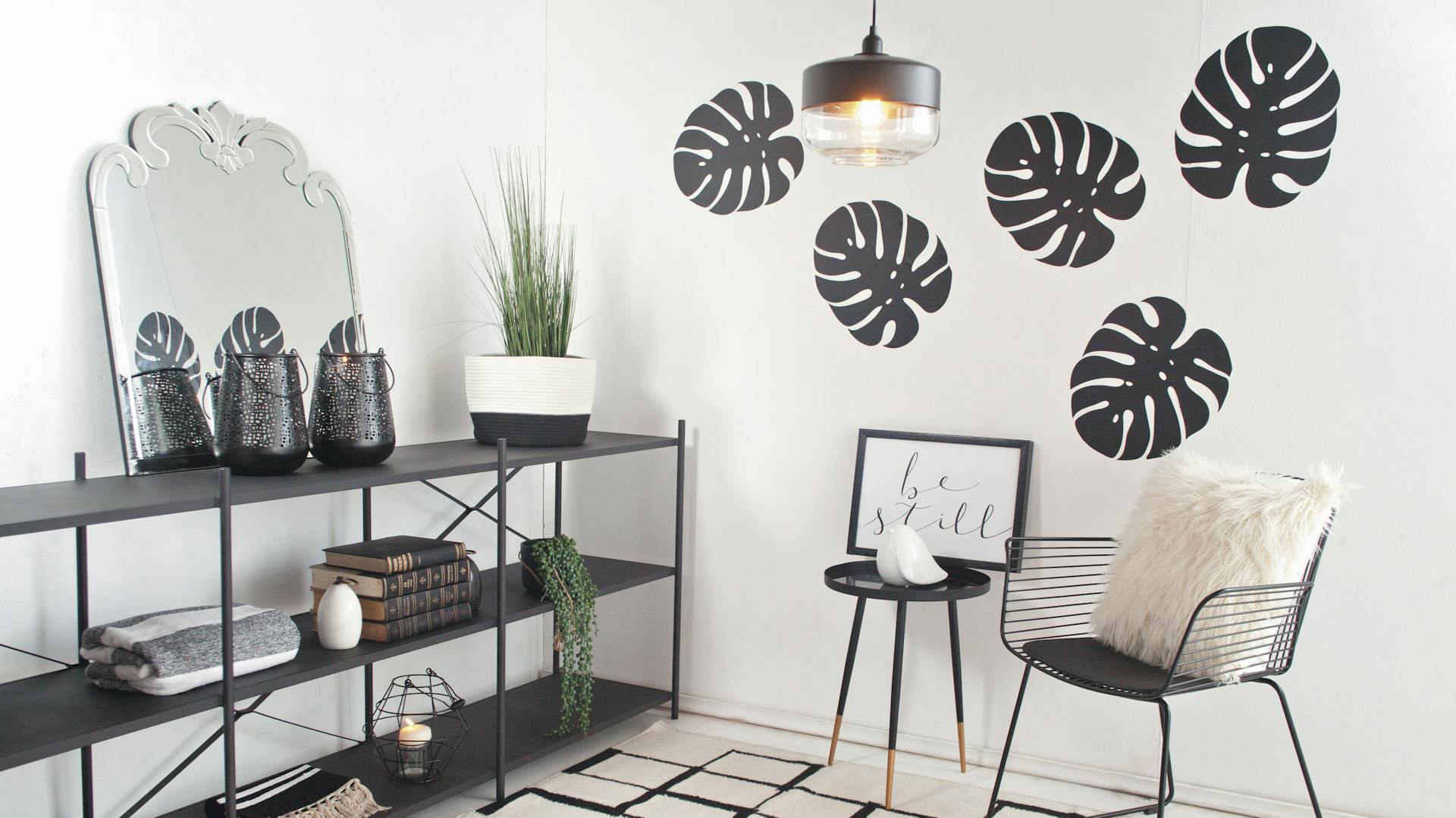 Kleine, moderne Sitzecke mit Regal und Wandtattoos in Blattform.