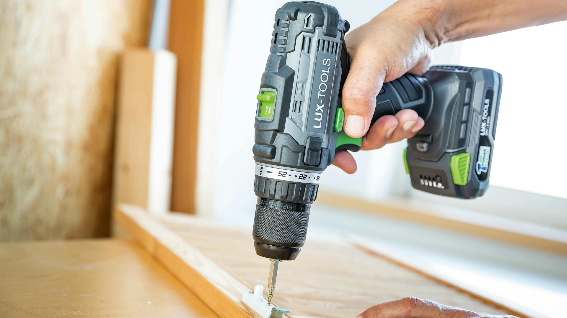 Akkuschrauber dreht Schraube in Holz